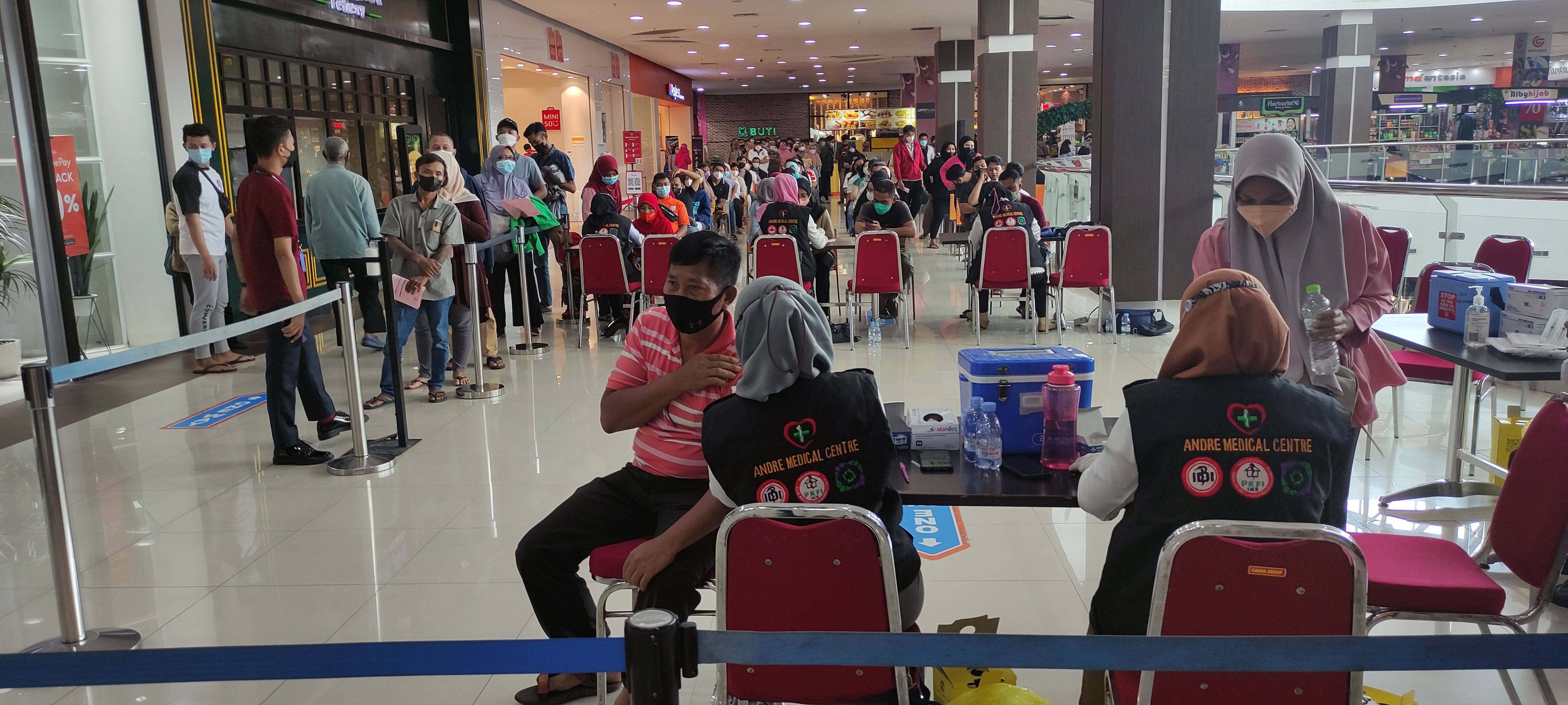 Antrean panjang warga yang akan vaksin booster terlihat di sebuah pusat perbelanjaan di Kabupaten Sidoarjo, Rabu (30/3)