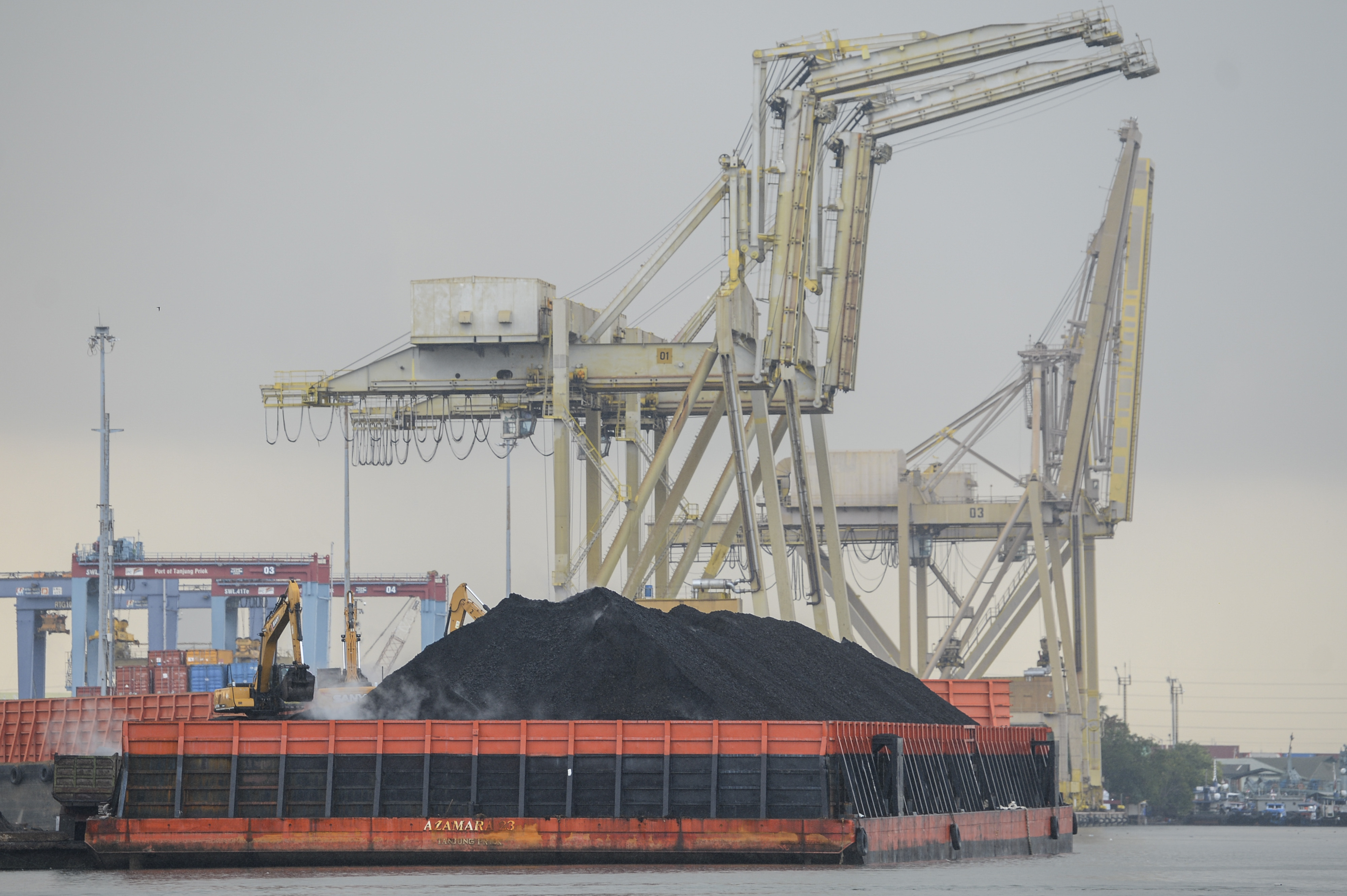 Pekerja mengoperasikan alat berat saat bongkar muat batu bara ke dalam truk di Pelabuhan Tanjung Priok, Jakarta Priok.