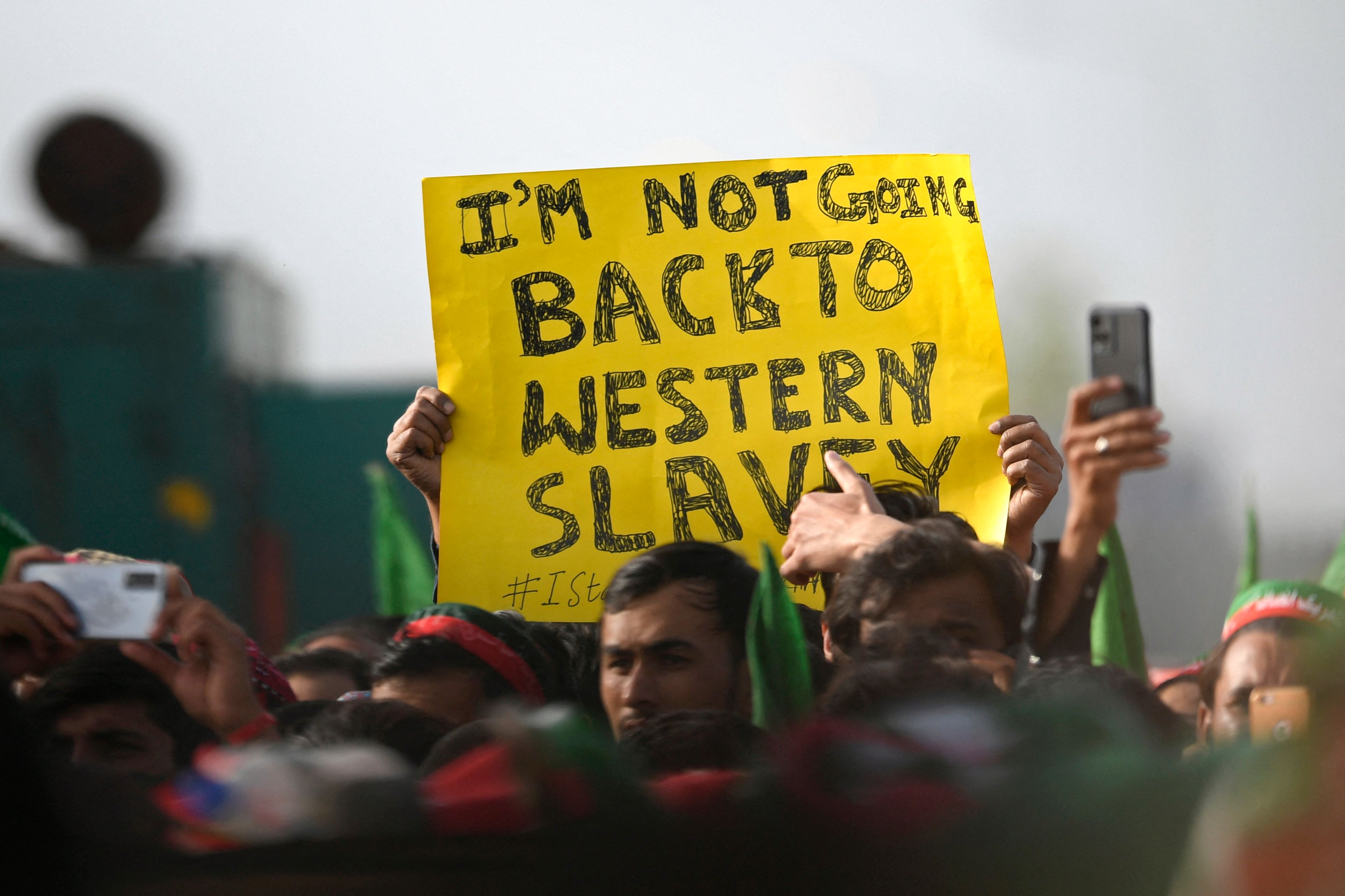 Pendukung PM Pakistan Imran Khan berunjuk rasa dengan bawa poster 'Saya tak akan kembali jadi budak Barat' di Islamabad, Minggu (27/3).  