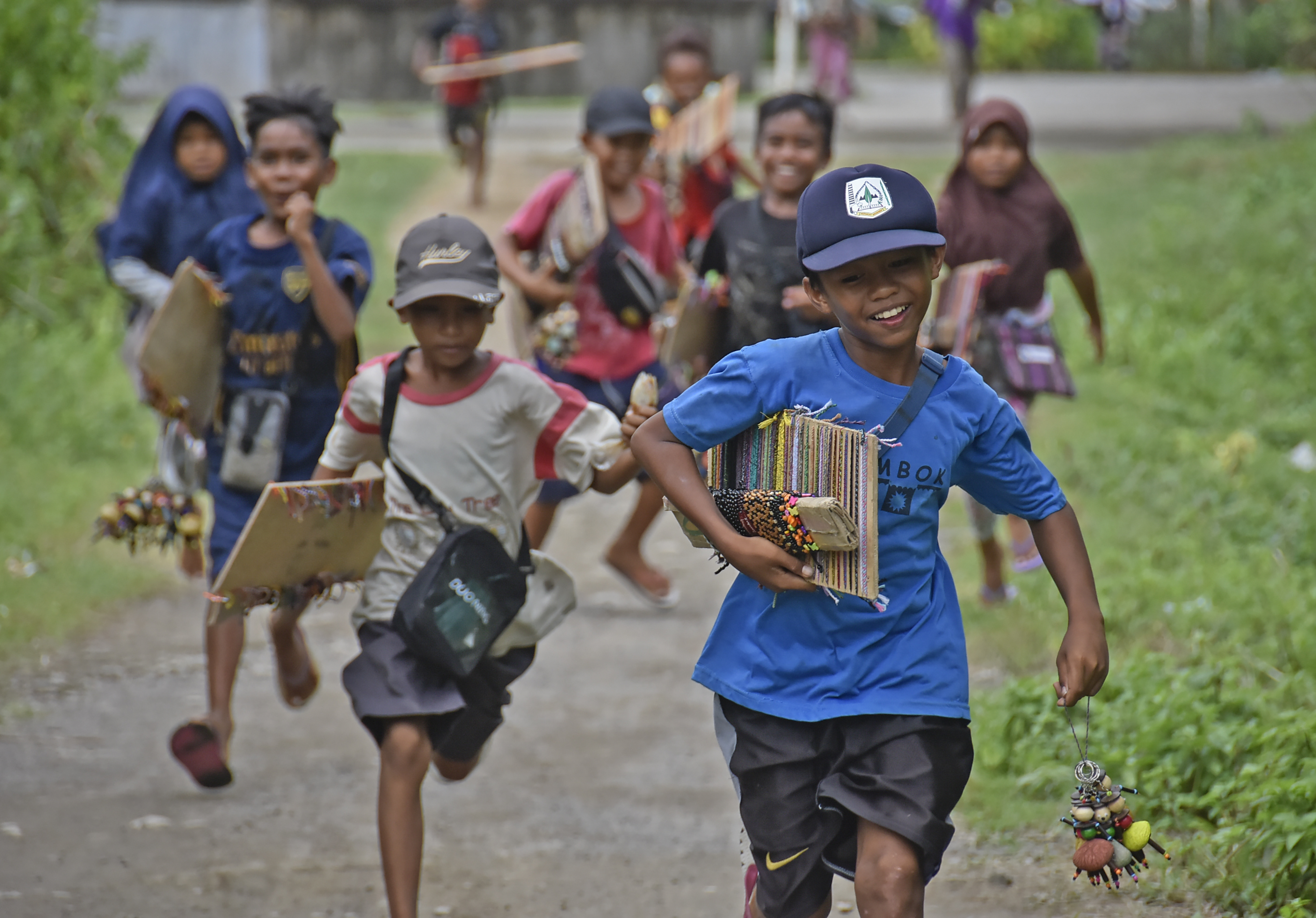 Sejumlah anak-anak pedagang suvenir berlarian mengejar wisatawan di pinggiran pantai Mandalika, Desa Kuta, Kecamatan Pujut, Praya, NTB.