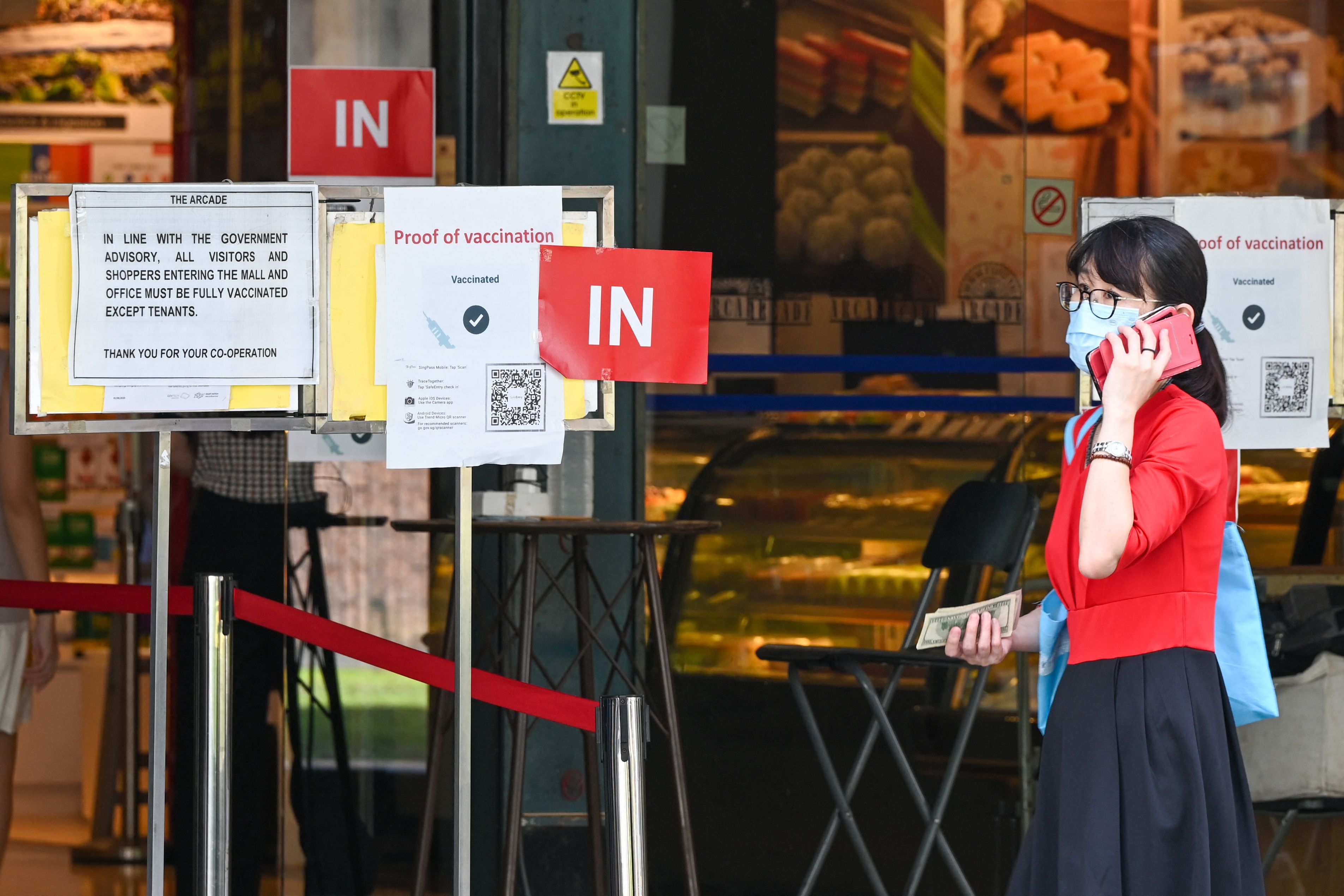 Tanda wajib sudah divaksin Covid-19 terpasang di gerbang masuk sebuah mal di Raffles Place, Singapura, Kamis (24/3). 