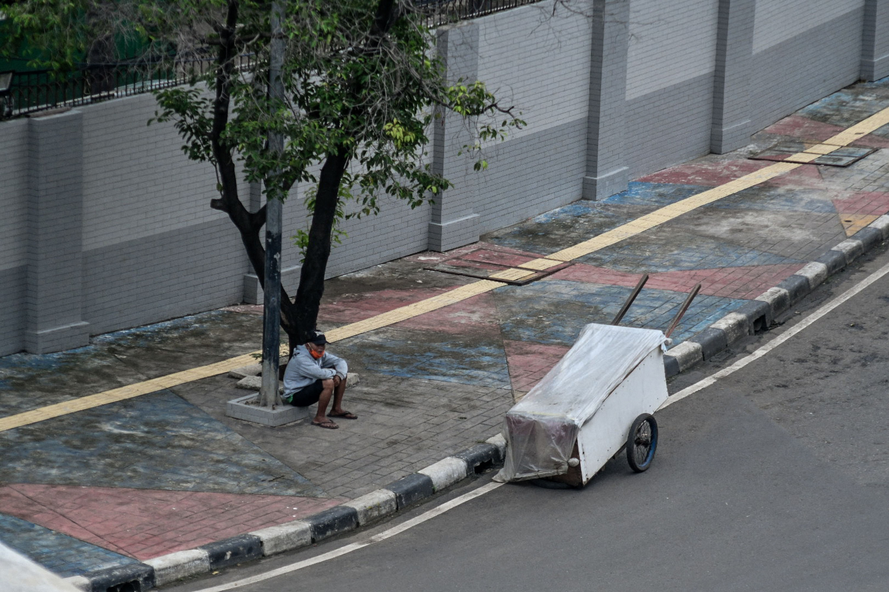 Penyandang Masalah Kesejahteraan Sosial (PMKS) sedang duduk di Kawasan Kuningan, Jakarta.