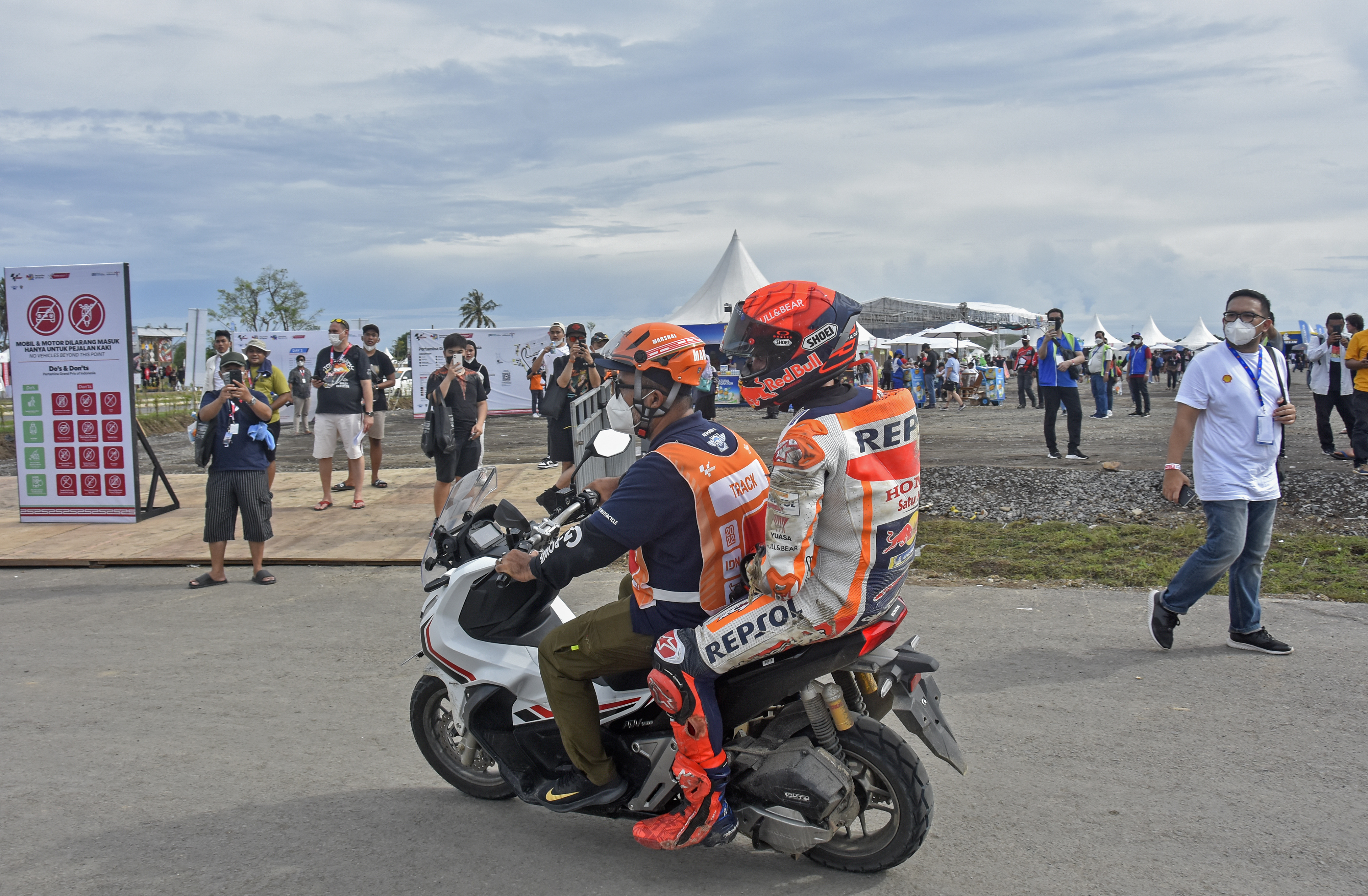 Pembalap Repsol Honda Team Marc Marquez membonceng marshal usai terjatuh saat kualifikasi MotoGP Seri Mandalika