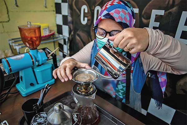 Restiawati tengah meracik kopi pesanan pembeli di kedai Kopi Netra.