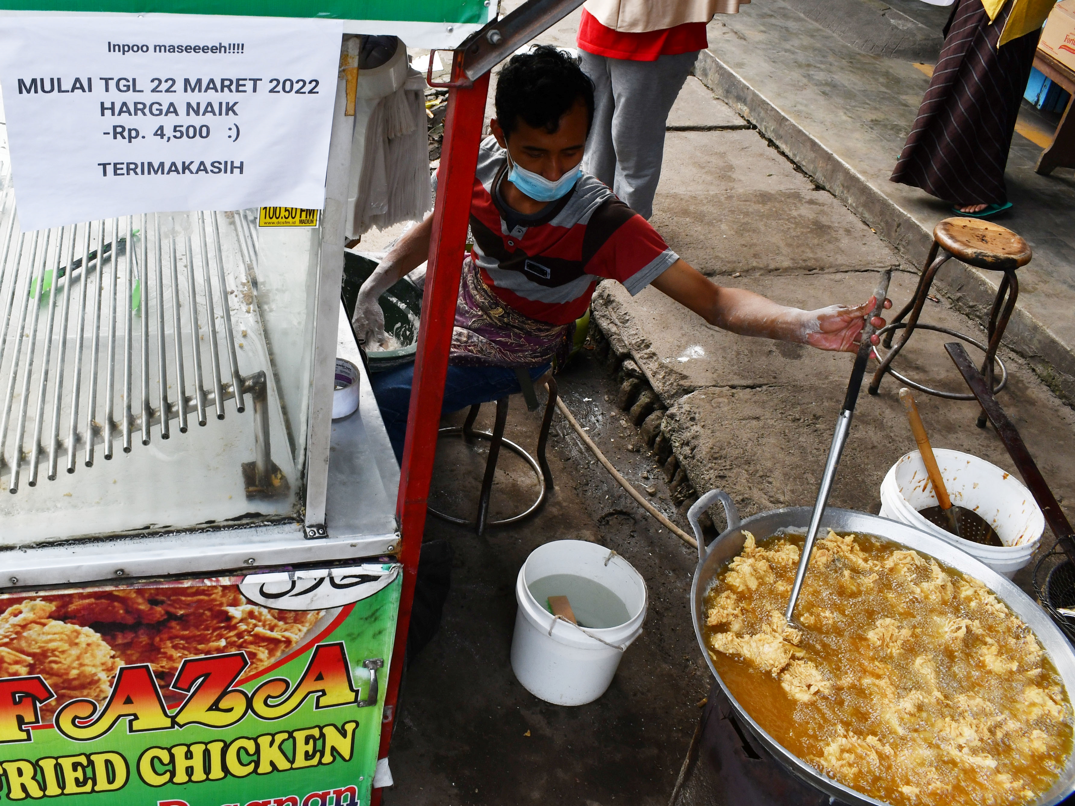 Pedagang menggoreng ayam jualannya di Pasar Pagotan, Kabupaten Madiun, Jawa Timur, Rabu (23/3/2022).