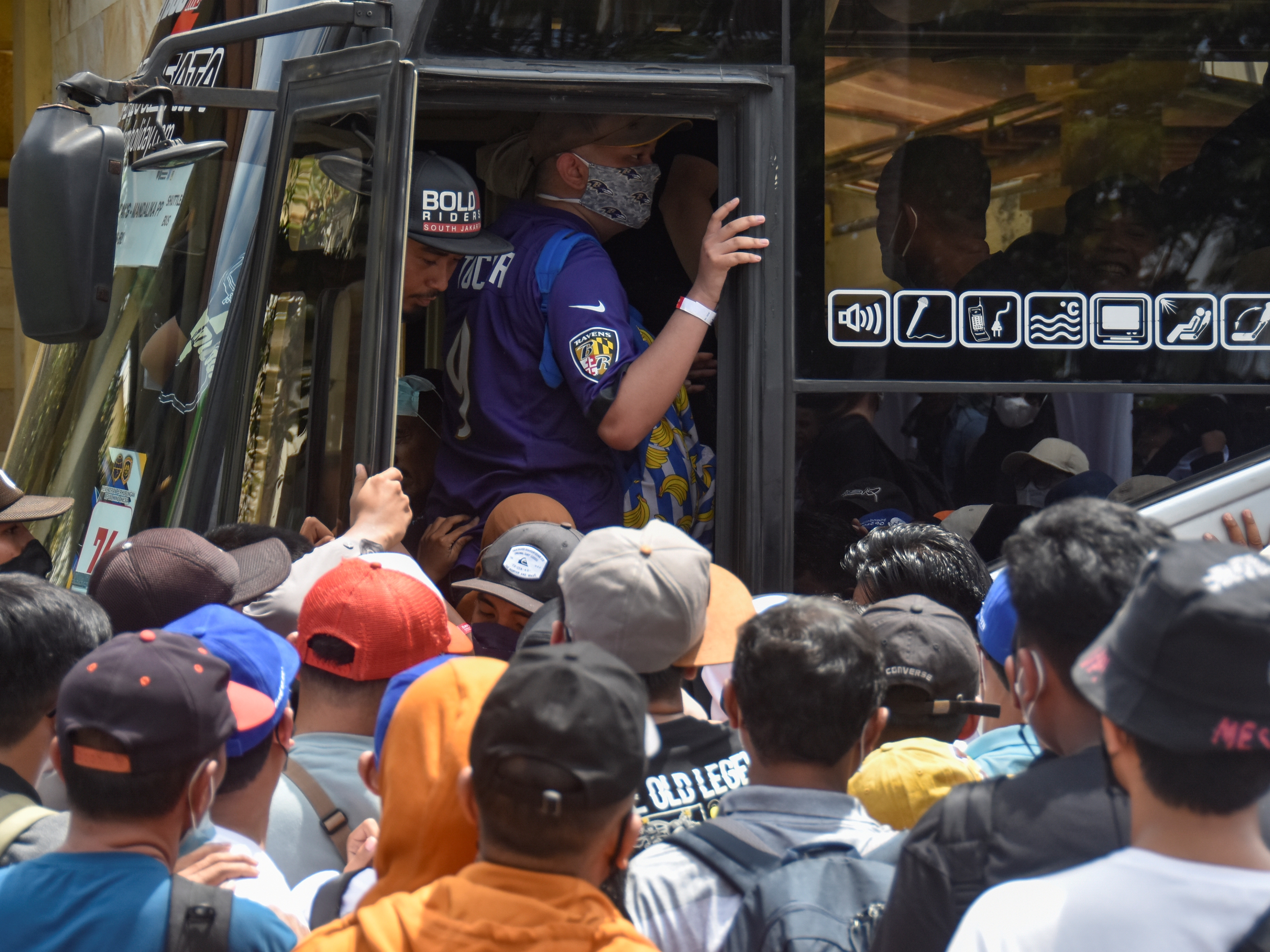 Sejumlah penonton berdesakan saat antre menaiki bus angkutan khusus menuju Mandalika untuk penonton MotoGP di Eks Bandara Selaparang.