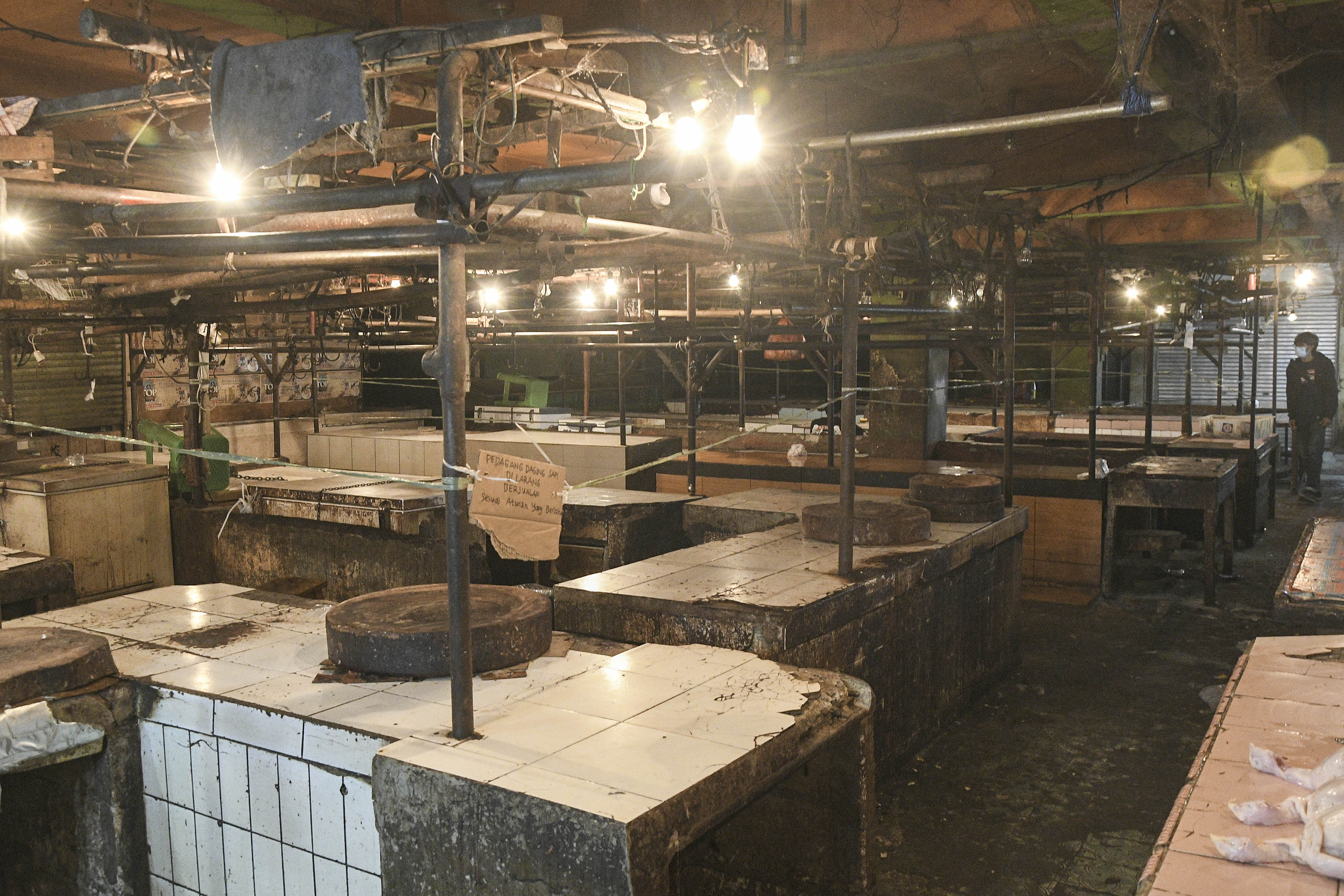 Seorang warga melintas di lapak pedagang sapi yang tutup di Pasar Tambun, Kabupaten Bekasi, Jawa Barat, Selasa (1/3/2022).