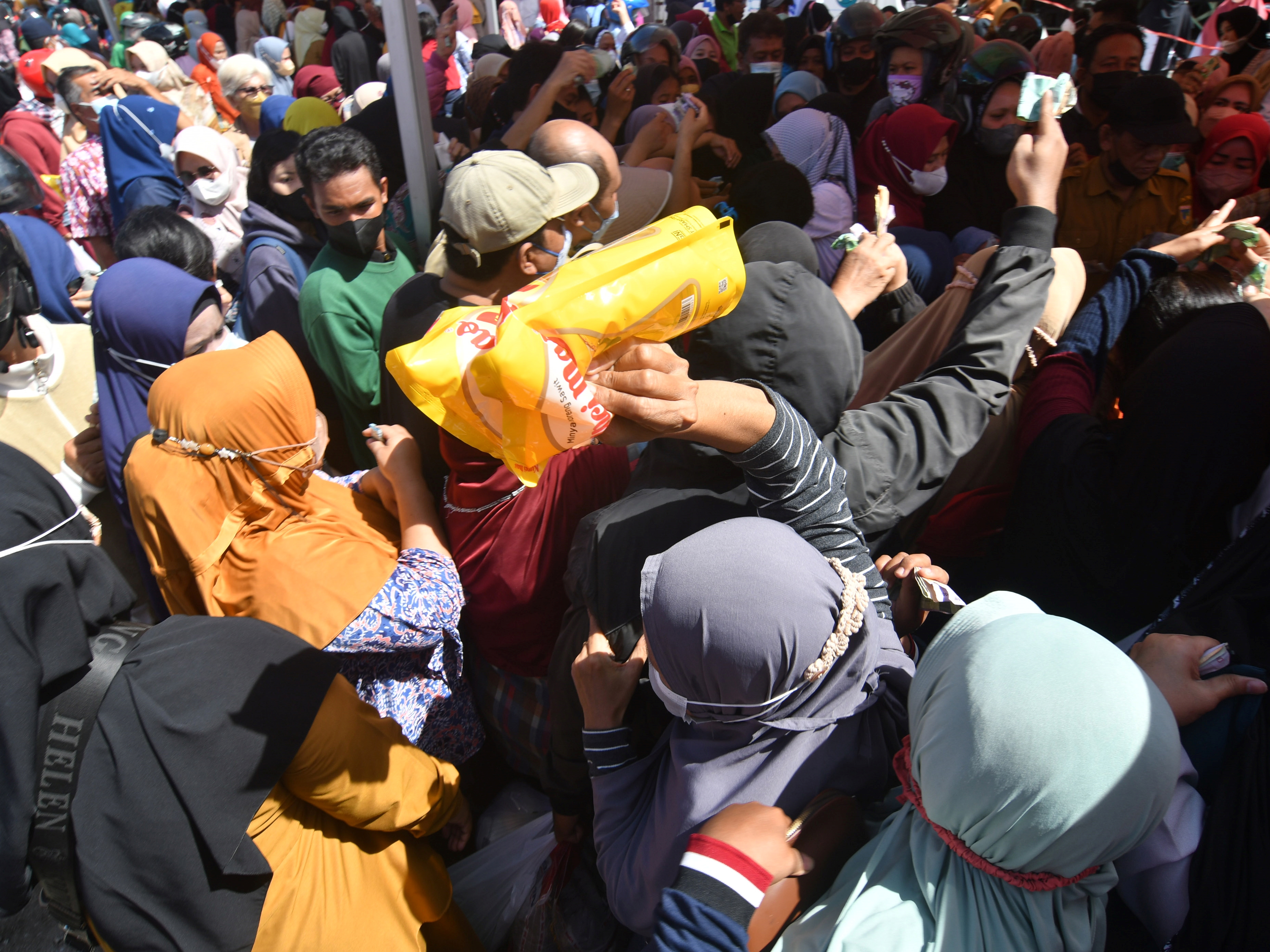 Warga mengantre saat membeli minyak goreng yang dijual di operasi pasar murah di Palu, Sulawesi Tengah, Selasa (15/3/2022).