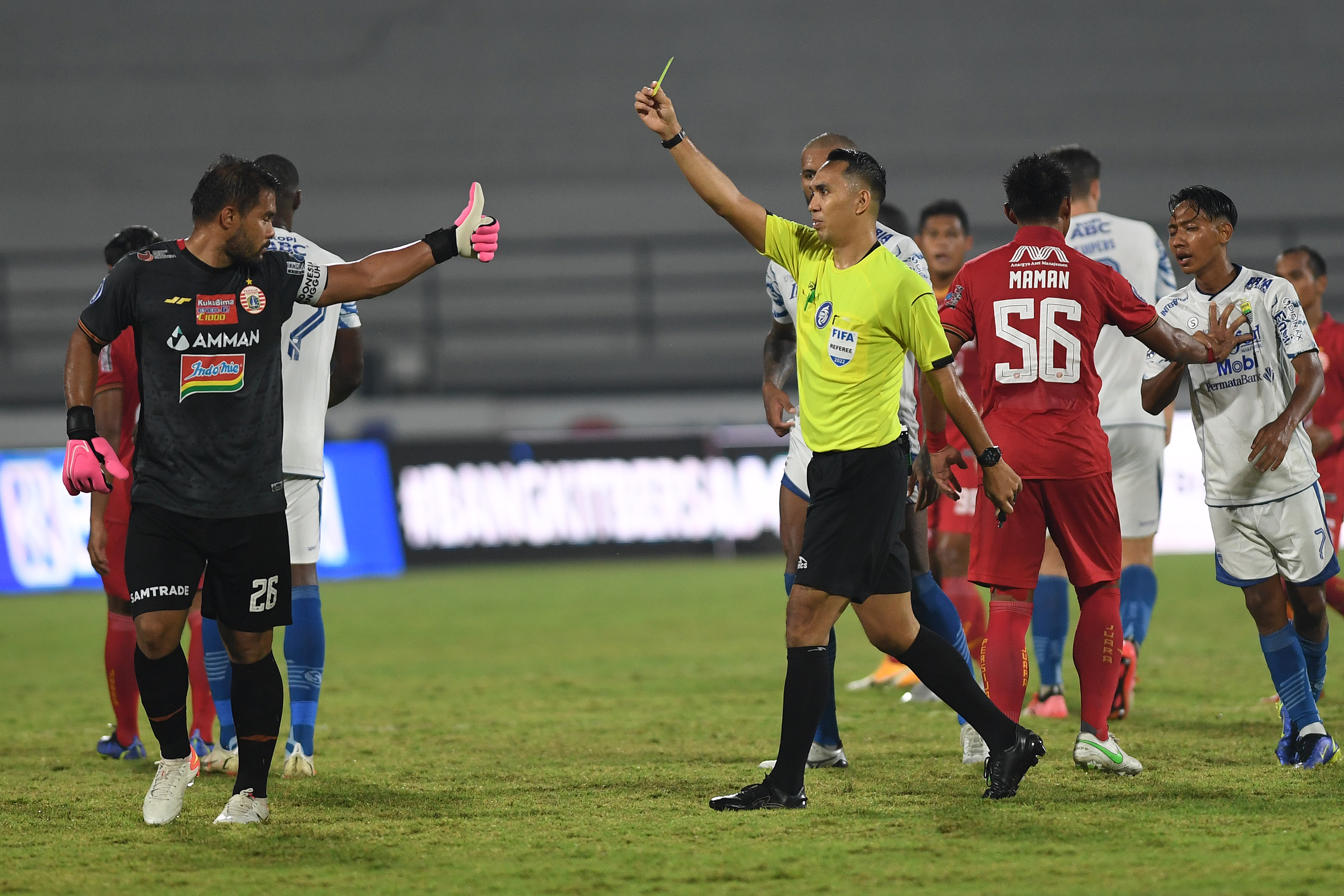 Penjaga gawnag persija Andirtany Ardhiyasa (kiri) diganjar kartu kuning oleh wasit dalam laga Liga 1 melawan Persib