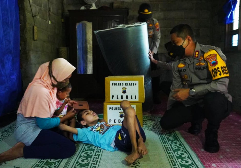 Kapolres AKB Eko Prasetyo menyerahkan bantuan kepada Muryanto yang berbaring dengan alas tikar.