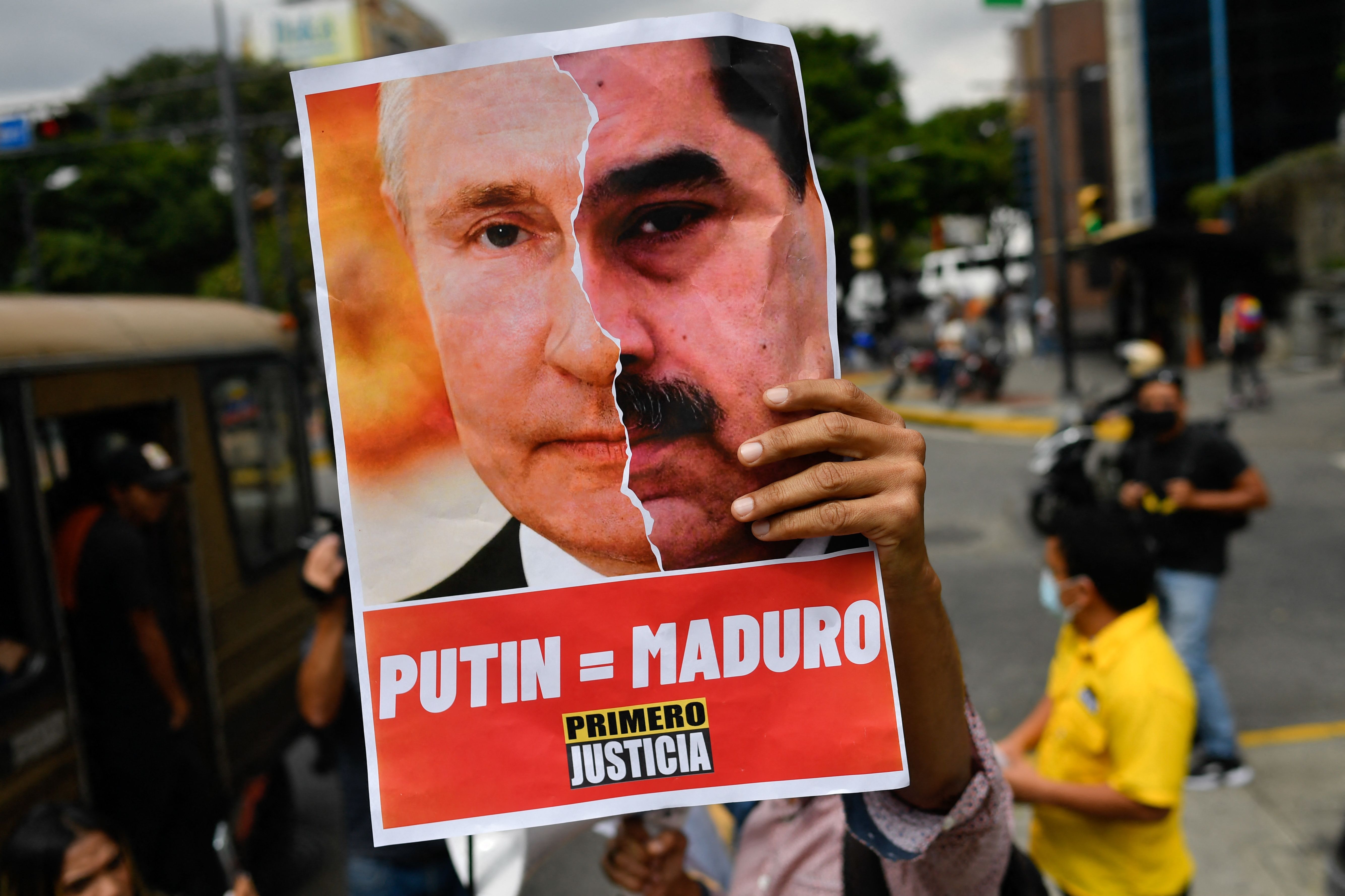 Pendukung partai oposisi Primero Justicia memegang poster yang menyamakan Putin dengan Maduro di Caracas, Venezuela, Jumat (4/3). 