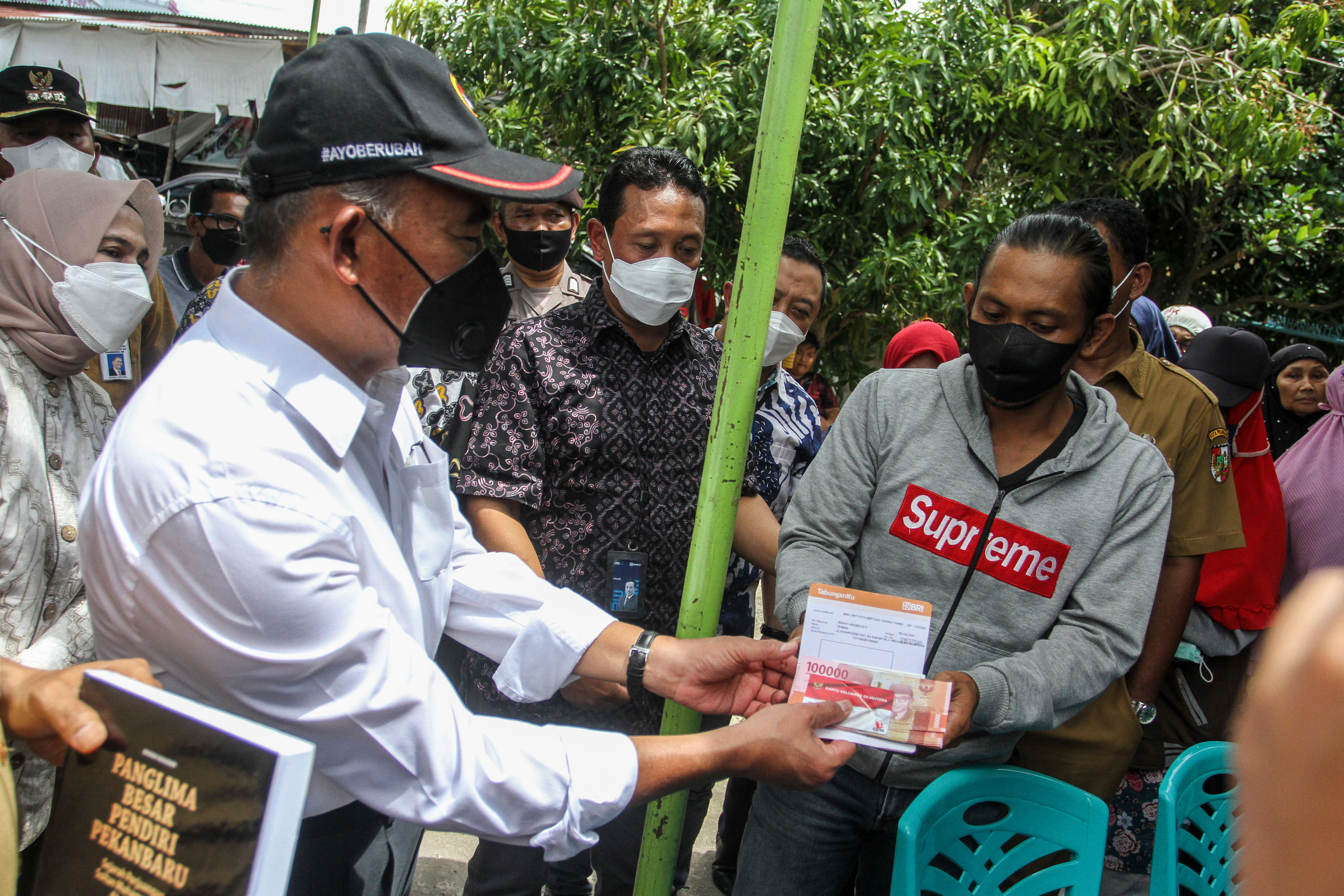 Menko PMK Muhadjir Effendy menyerahkan bantuan sosial kepada warga.