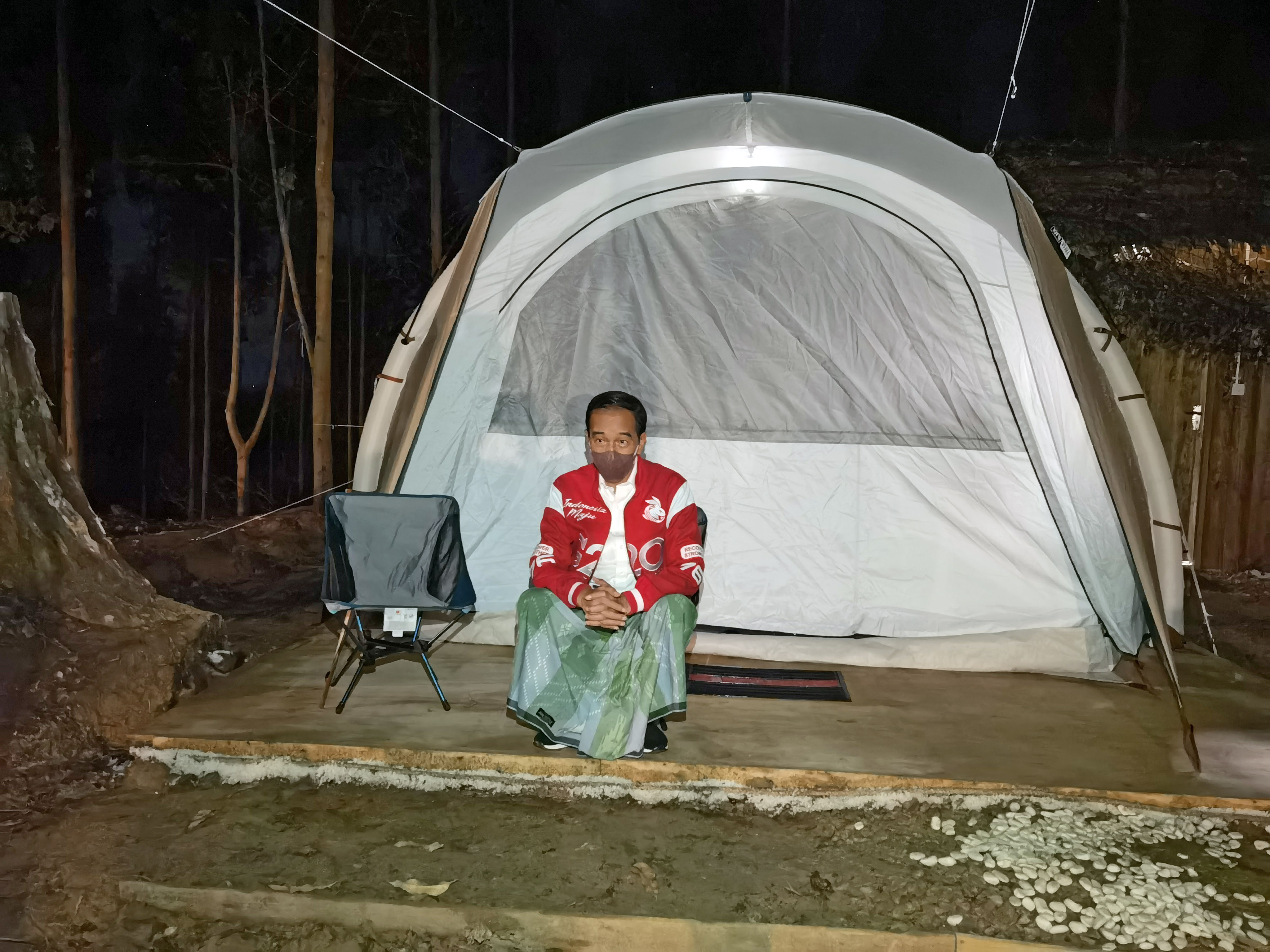 Presiden Joko Widodo duduk di depan tenda saat bermalam di titik nol Ibu Kota Negara (IKN) Nusantara.