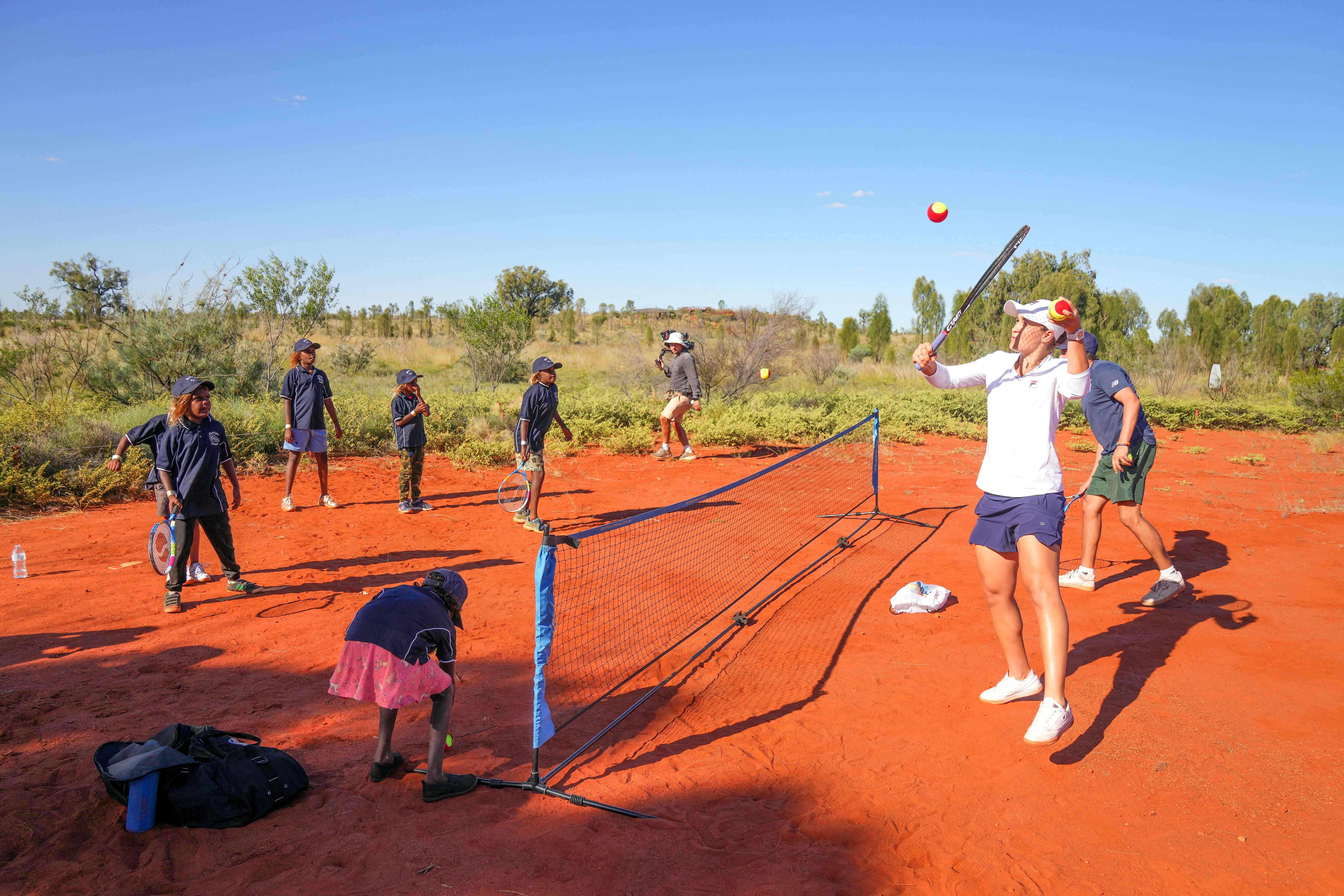 Foto yang dirilis 28 Februari 2022, tampak Ashleigh Barty bermain tenis dengan dengan para siswa di Sekolah Mutitjulu, Uluru, Australia. 