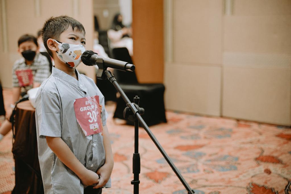 Seorang anak peserta kompetisi Spelling Bee 2022 tengah menunjukkan kemampuannya di depan juri. 