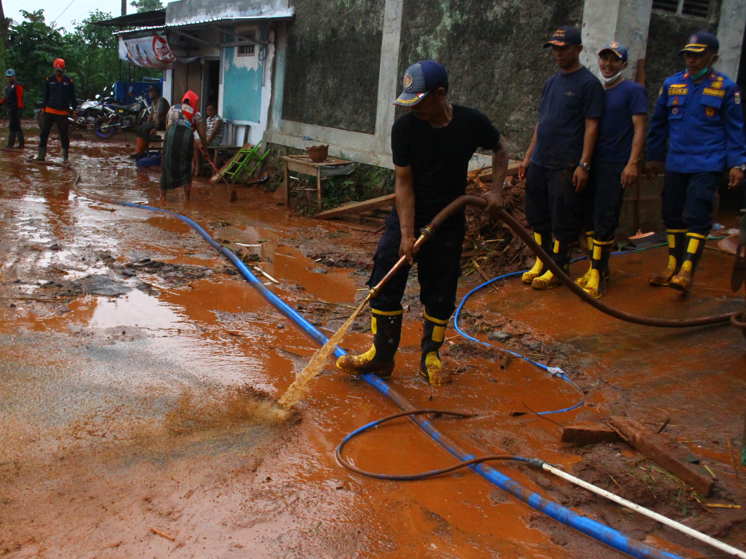 Petugas pemadam kebakaran membantu membersihkan sisa banjir lumpur di Desa Srigading, Lawang, Malang, Jawa Timur, Rabu (9/3/2022).