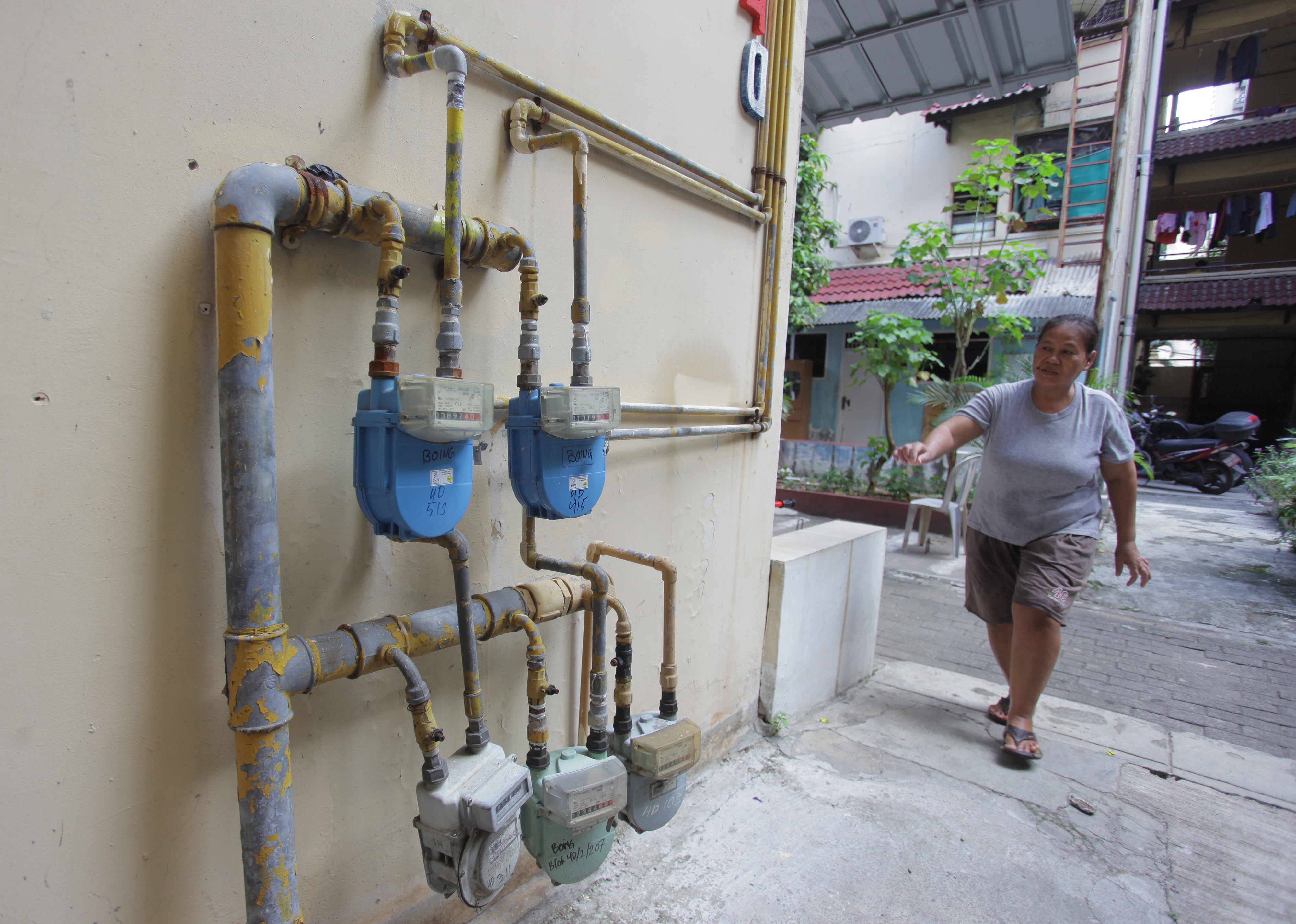 Ilustrasi: Warga melintas di sekitar jaringan pipa gas milik PGN di Kompleks Rusun Boing, Kemayoran