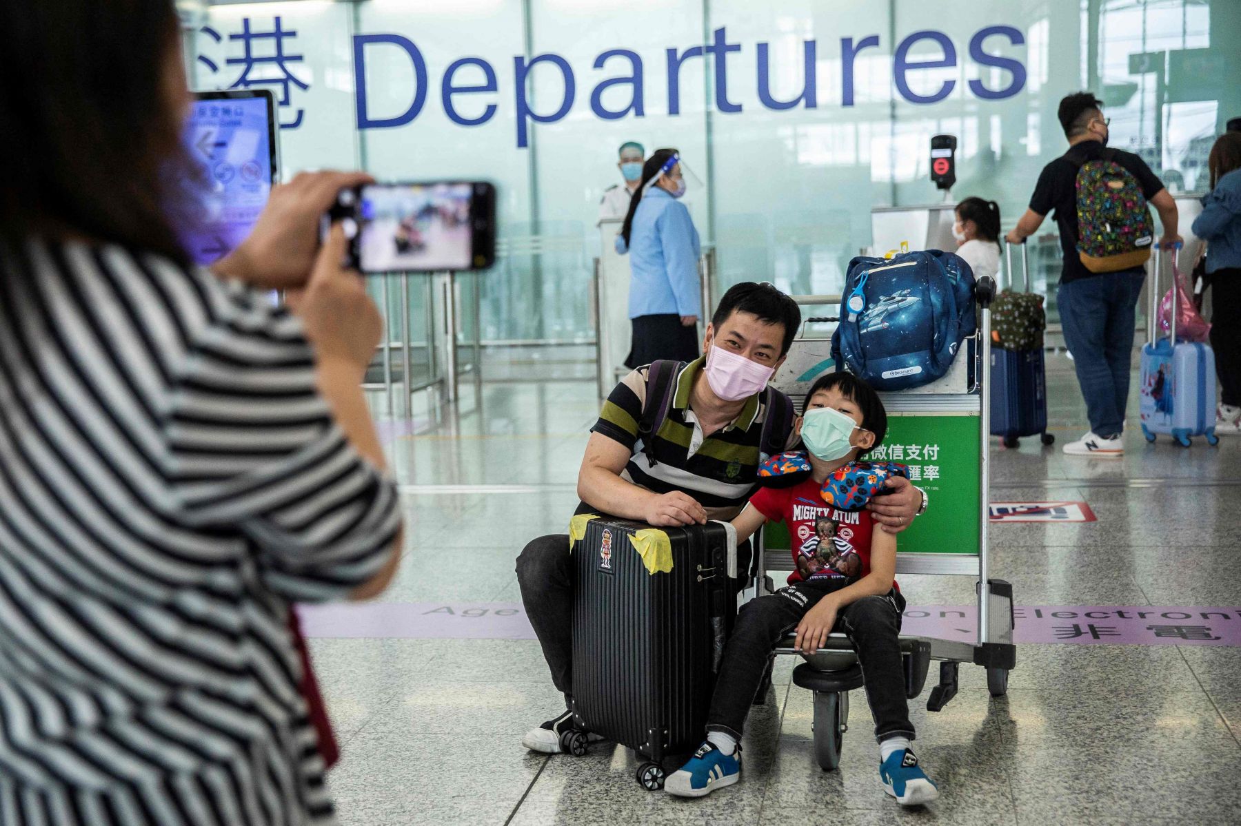 Keluarga mengambil foto di gerbang keberangkatan Bandara Internasional Hong Kong. 