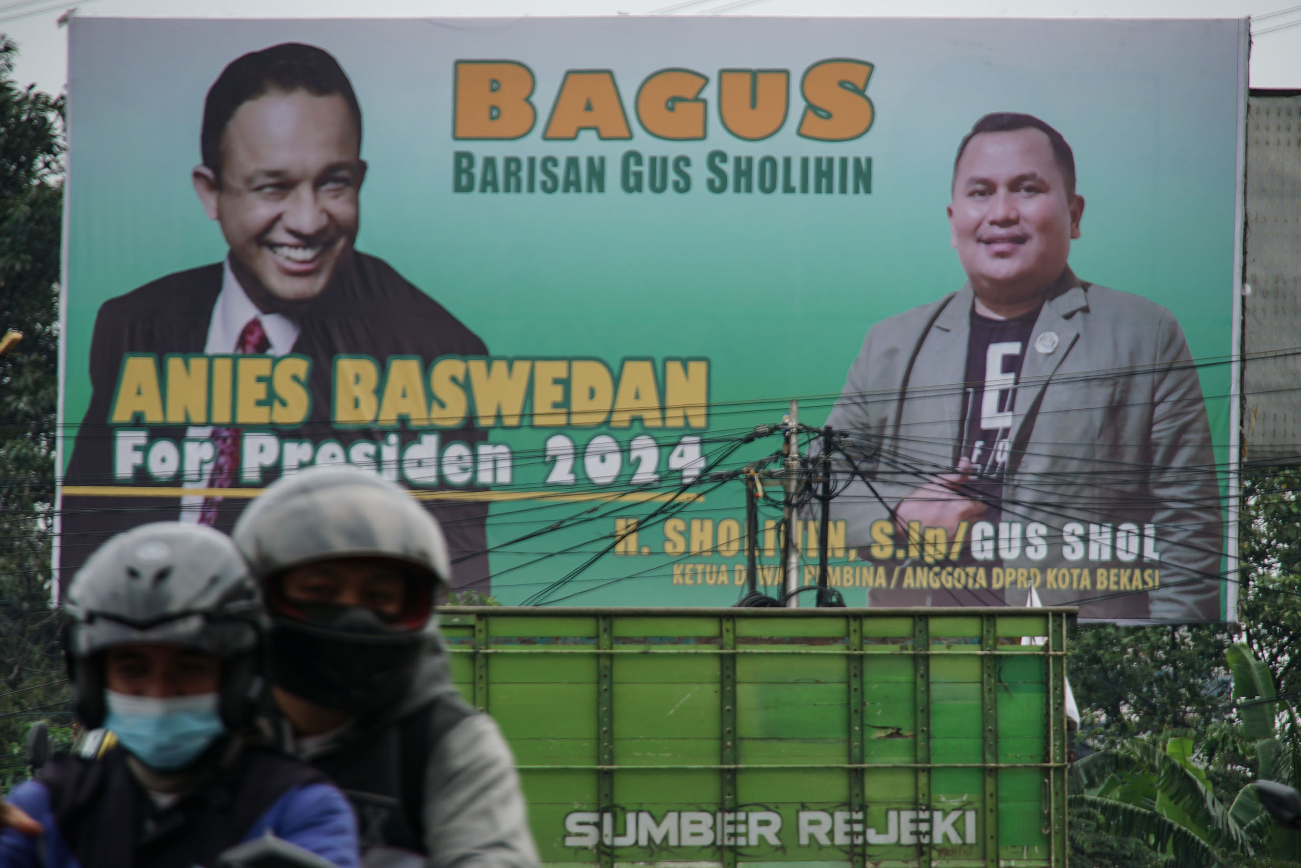 Pengendara melintas di depan baliho bertuliskan Anies Baswedan For Presiden 2024 
