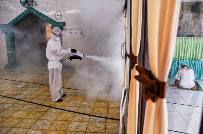 Ilustrasi - Petugas melakukan penyemprotan disinfektan di masjid wilayan Medan, Sumatra Utara.