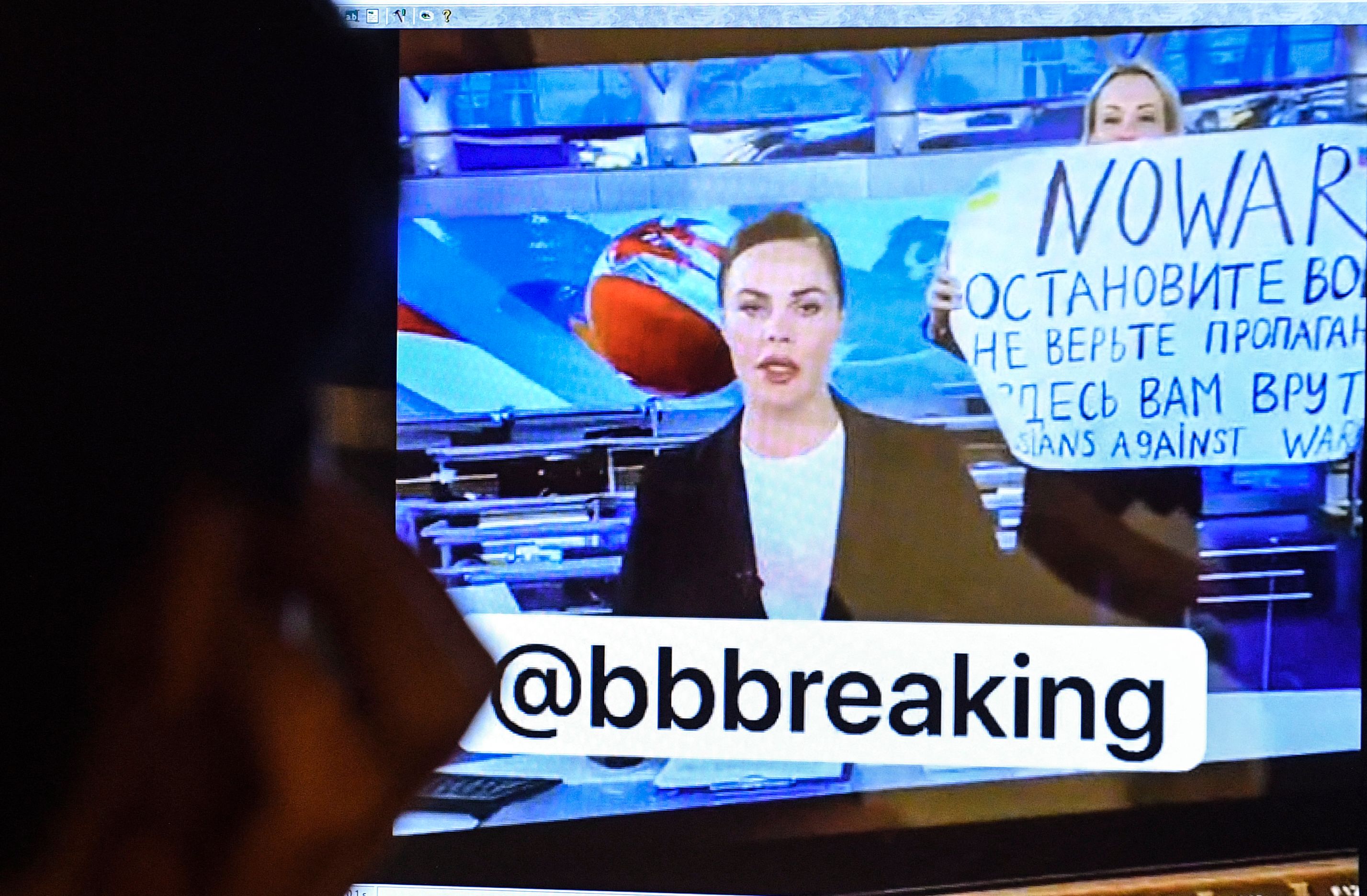 Marina Ovsyannikova membentangkan poster anti perang saat tayangan breaking news, Senin (14/3)