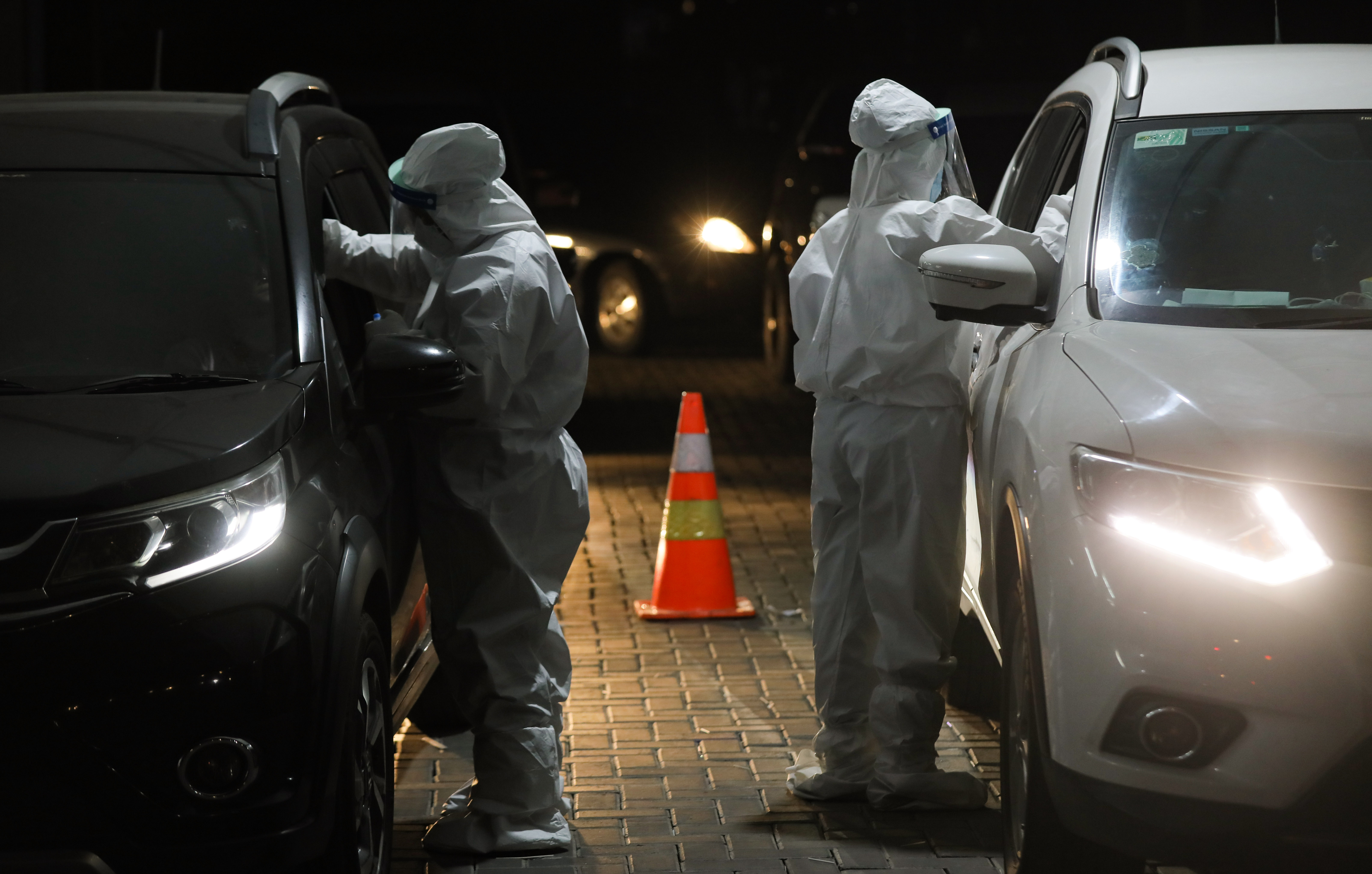 Petugas medis melakukan tes swab PCR warga dari dalam mobil atau drive thru di Swab PCR FastLab Bumame kawasan Kebon Jeruk