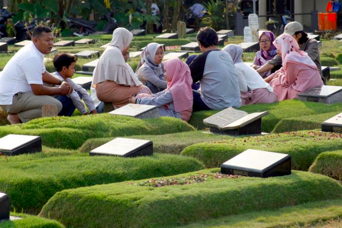 Warga berdoa di makam keluarga saat ziarah kubur di Tempat Pemakaman Umum (TPU) Pondok Ranggon, Jakarta.