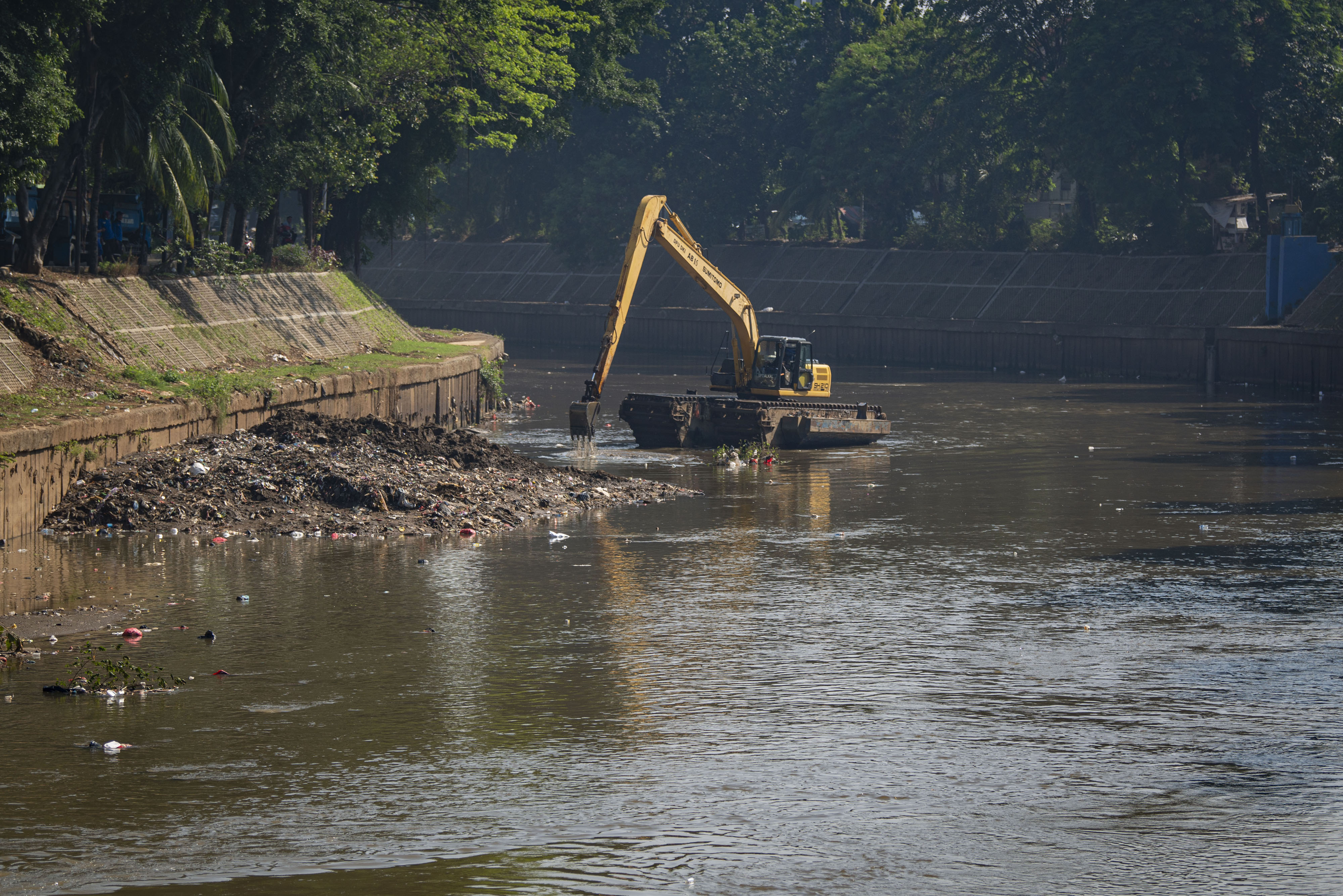 Petugas menggunakan ekskavator untuk mengeruk lumpur sedimentasi Sungai Ciliwung di Kampung Melayu, Jakarta.