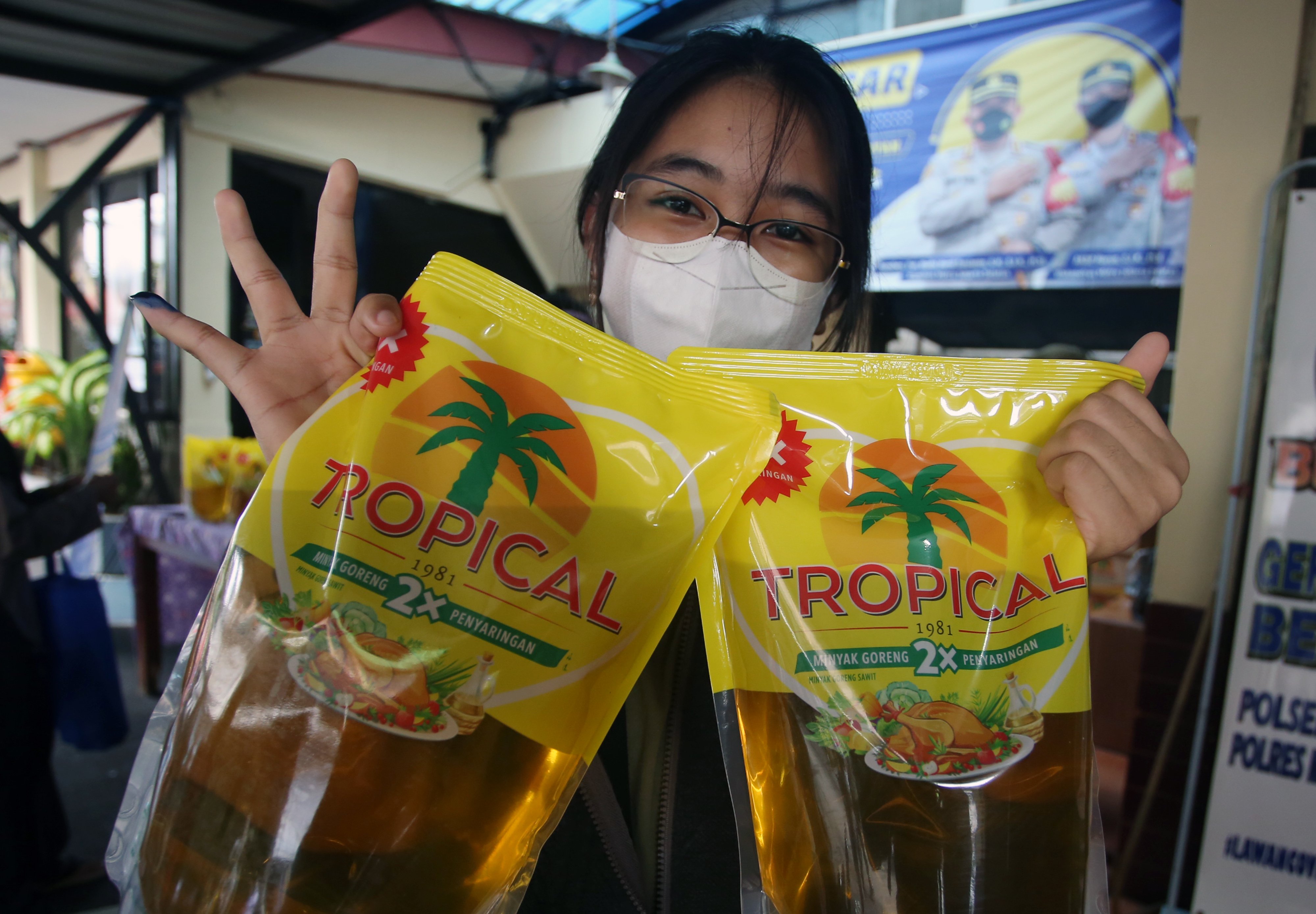Seorang warga membawa minyak goreng dalam kemasan.