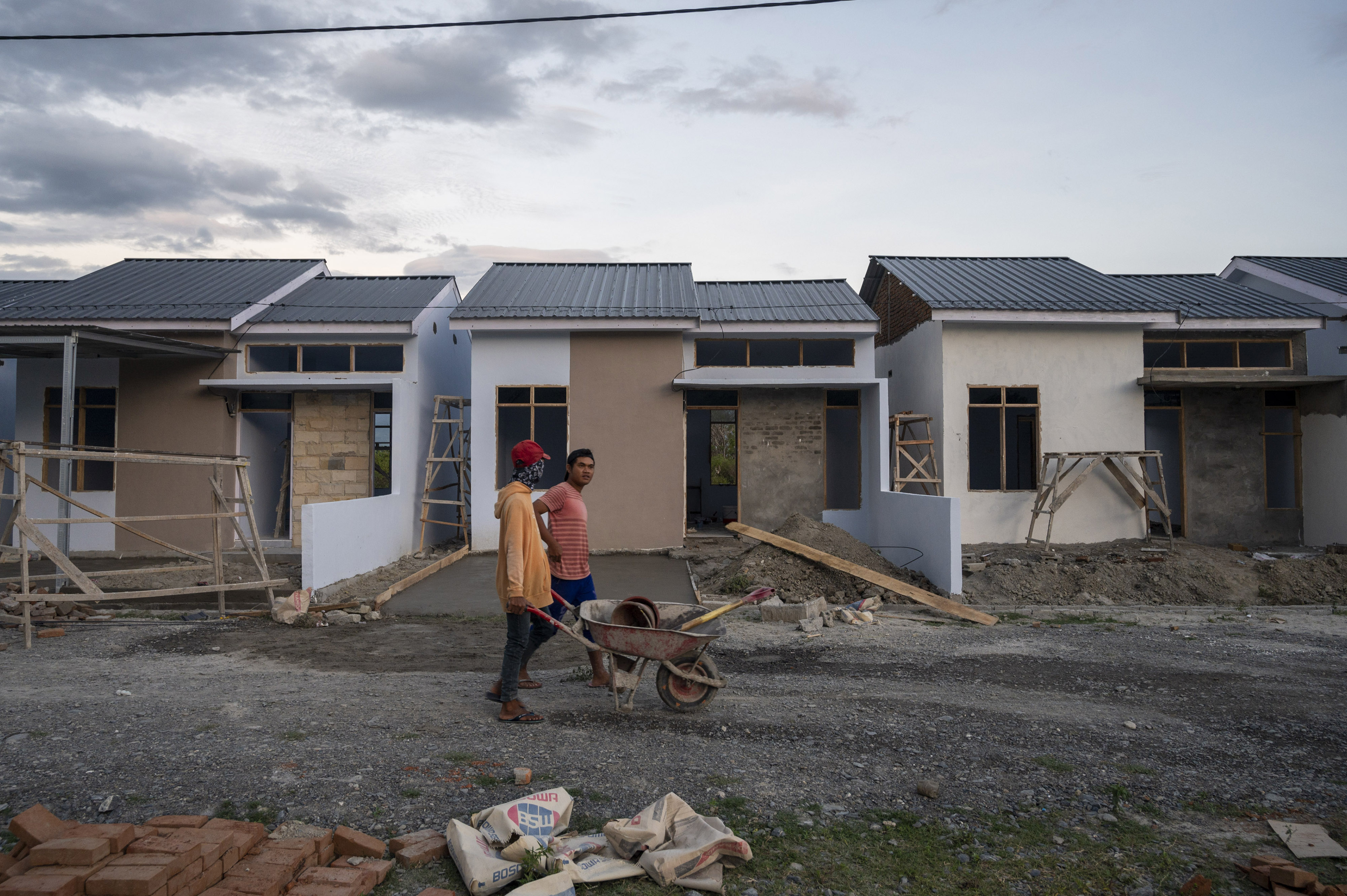 Aktivitas pekerja saat menyelesaikan pembangunan perumahan di Sigi, Sulawesi Tengah.