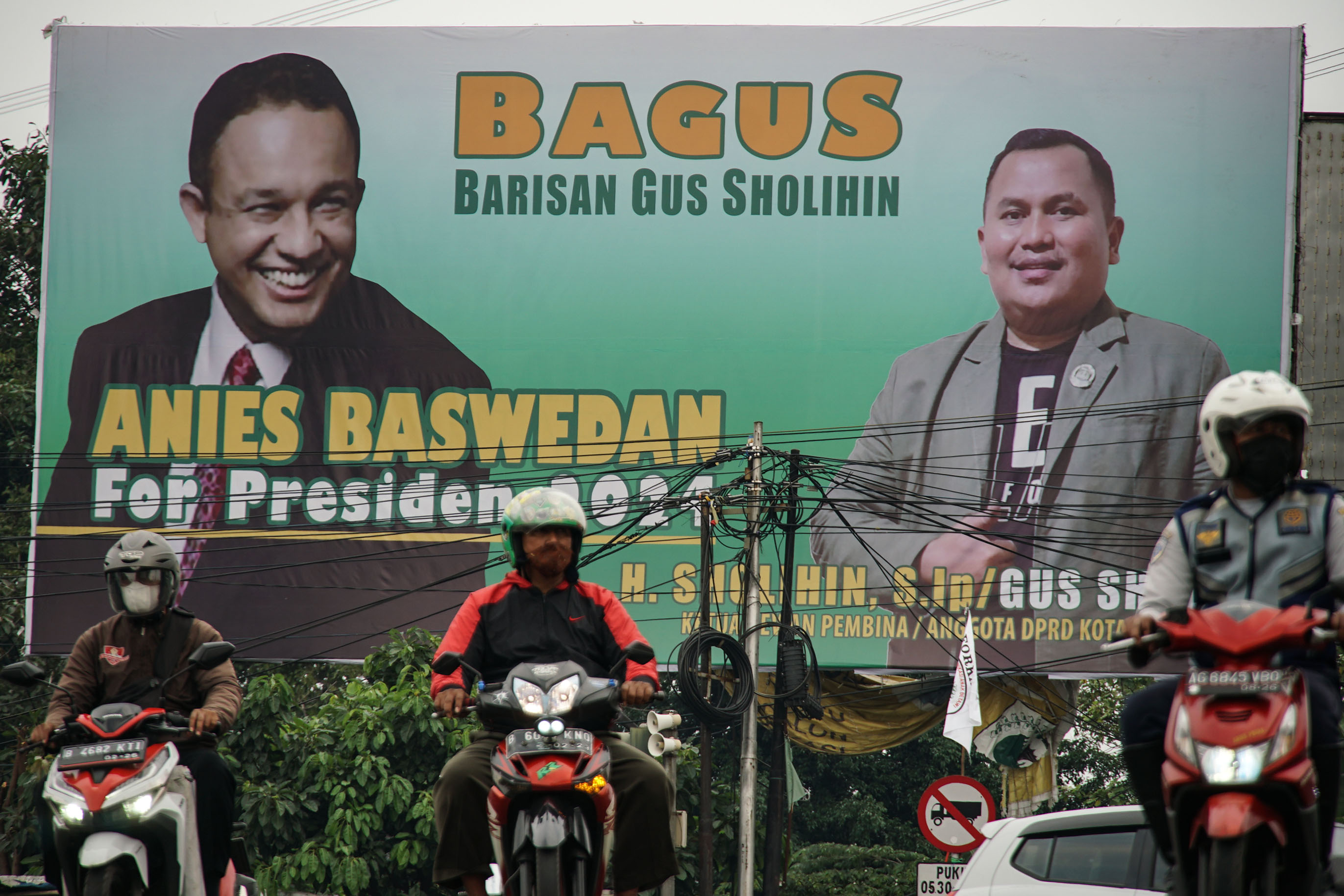 Pengendara melintas di depan baliho bertuliskan Anies Baswedan For Presiden