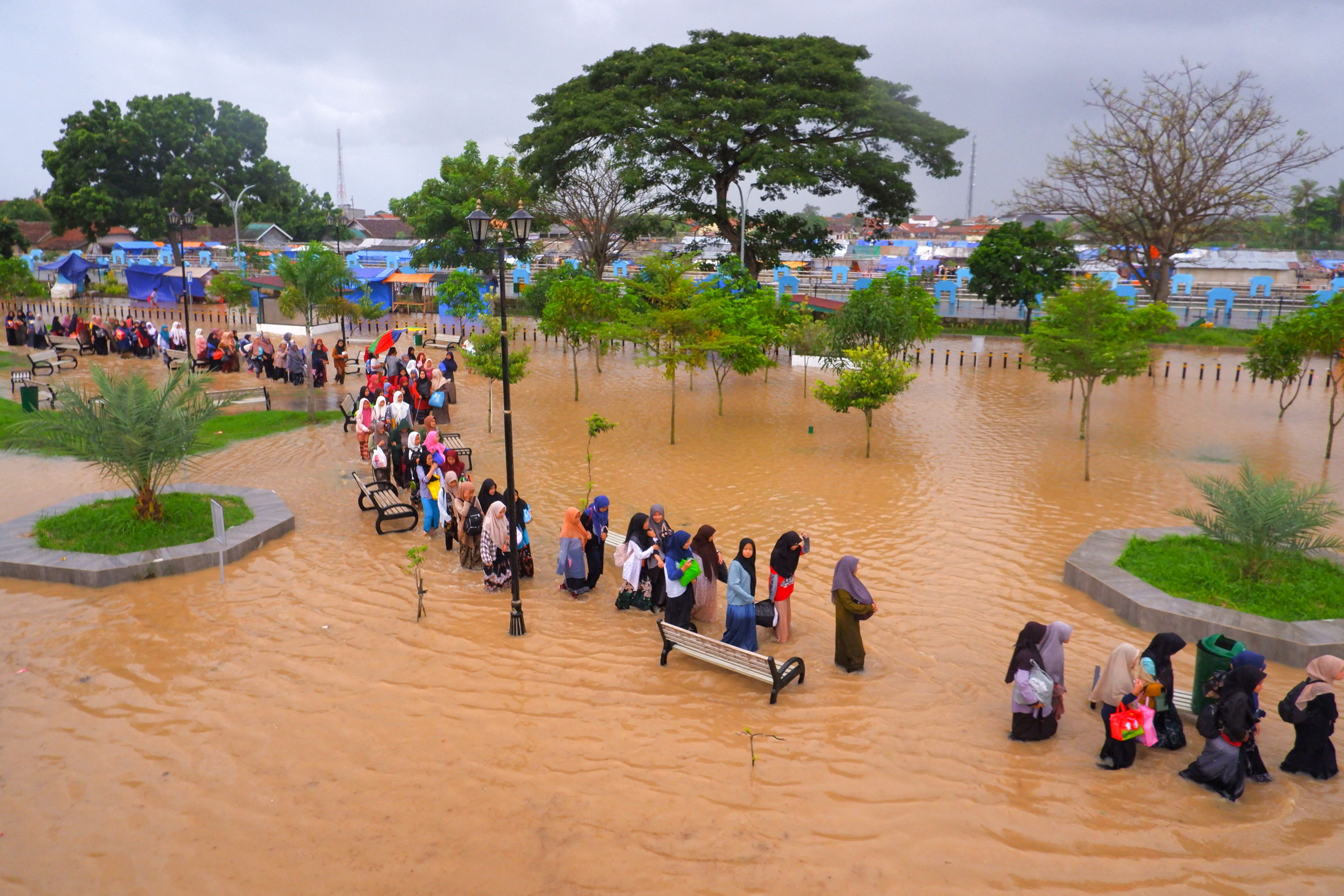 Warga menyusuri daerah yang teredam banjir untuk mengungsi ke daerah yang lebih tinggi di Serang, Banten, Selasa (1/3).  