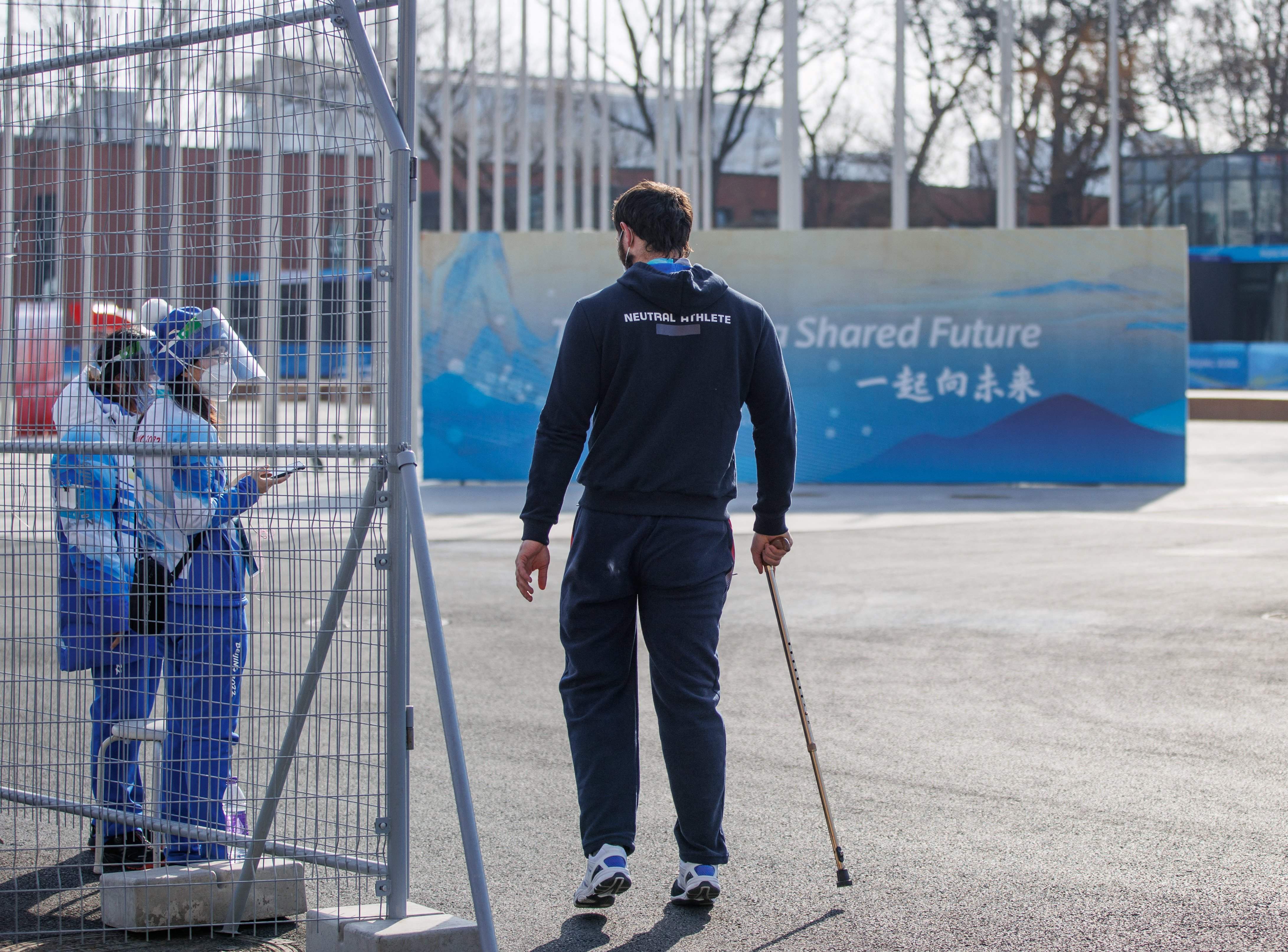 Atlet dengan jaket Atlet Netral berjalan di lokasi Paralimpiade musim dingin Beijing