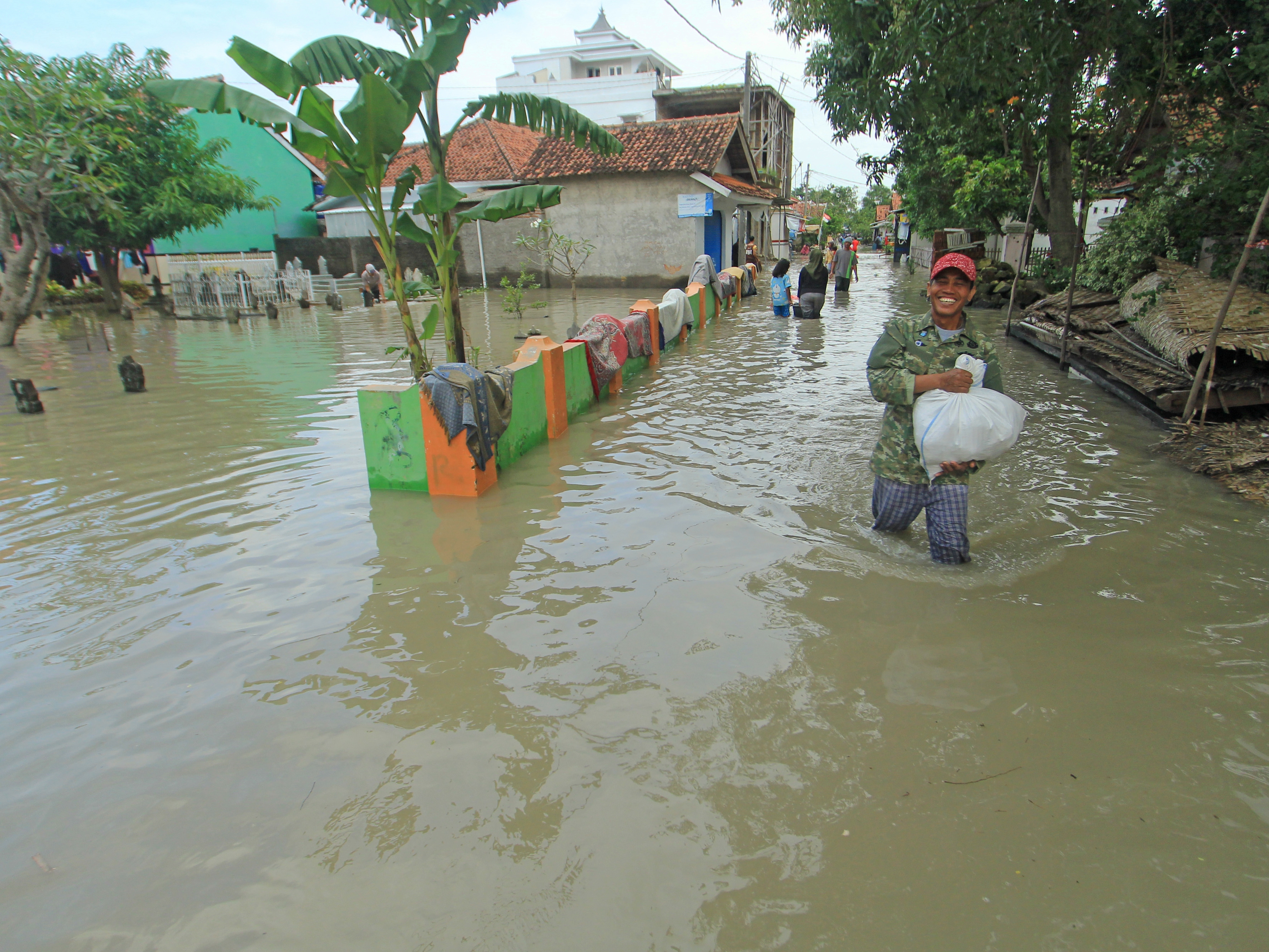 Warga berjalan menerobos banjir yang merendam Desa Suranenggala Lor, Kecamatan Suranenggala, Kabupaten Cirebon, Jabar, Selasa (19/1/2021).