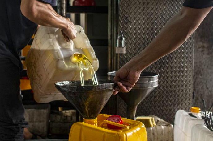 Pekerja mengisi minyak goreng curah ke dalam jerigen di salah satu tempat pengisian di kawasan Cipete, Jakarta.