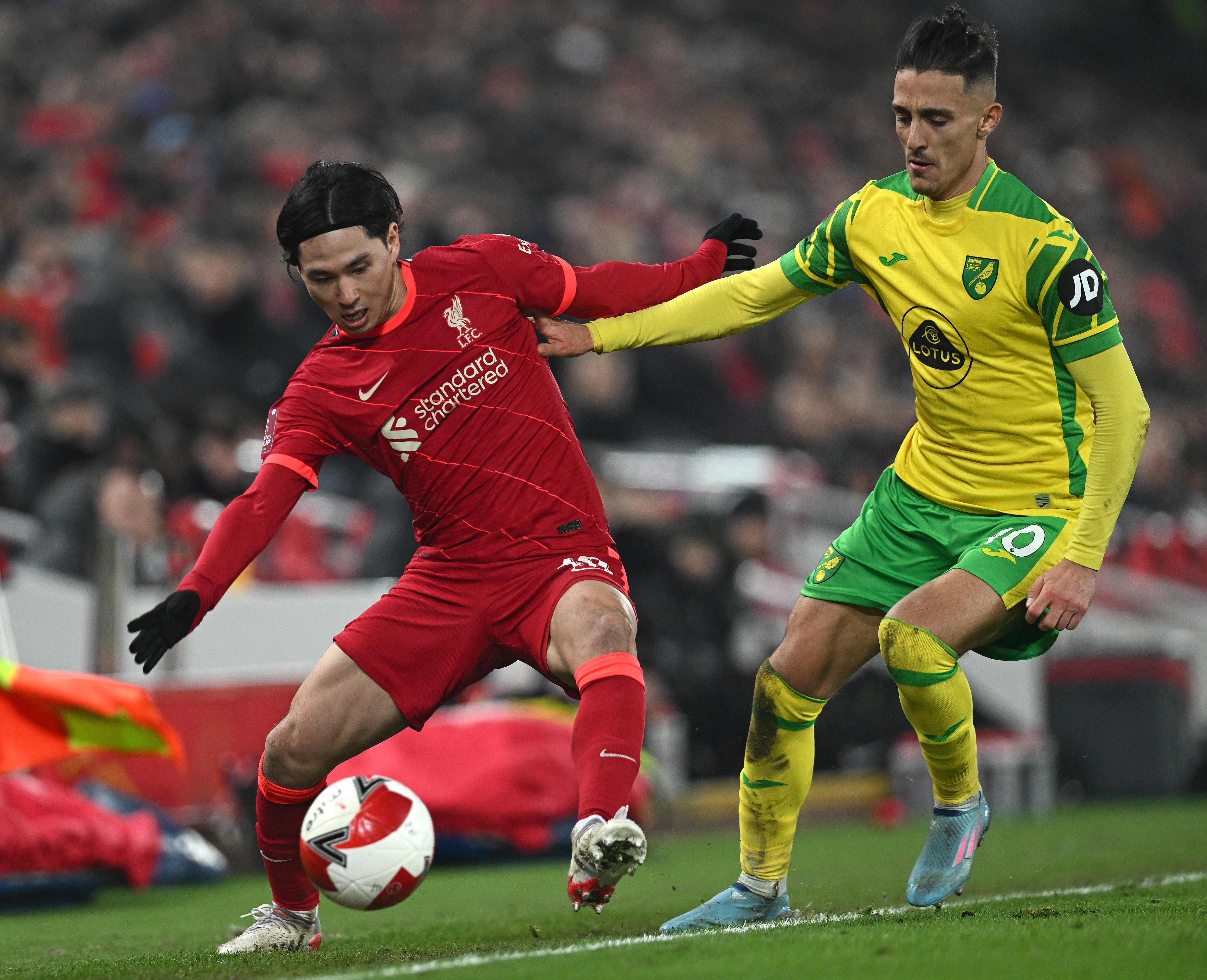 Penyerang Liverpool Takumi Minamino (kiri) berusaha melewati hadangan pemain Norwich di laga Piala FA.