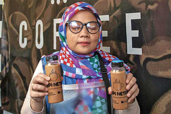 Founder Kopi Netra yang juga penyandang disabilitas, Restiawati, memperlihatkan kopi racikannya di kedai Kopi Netra, Jakarta
