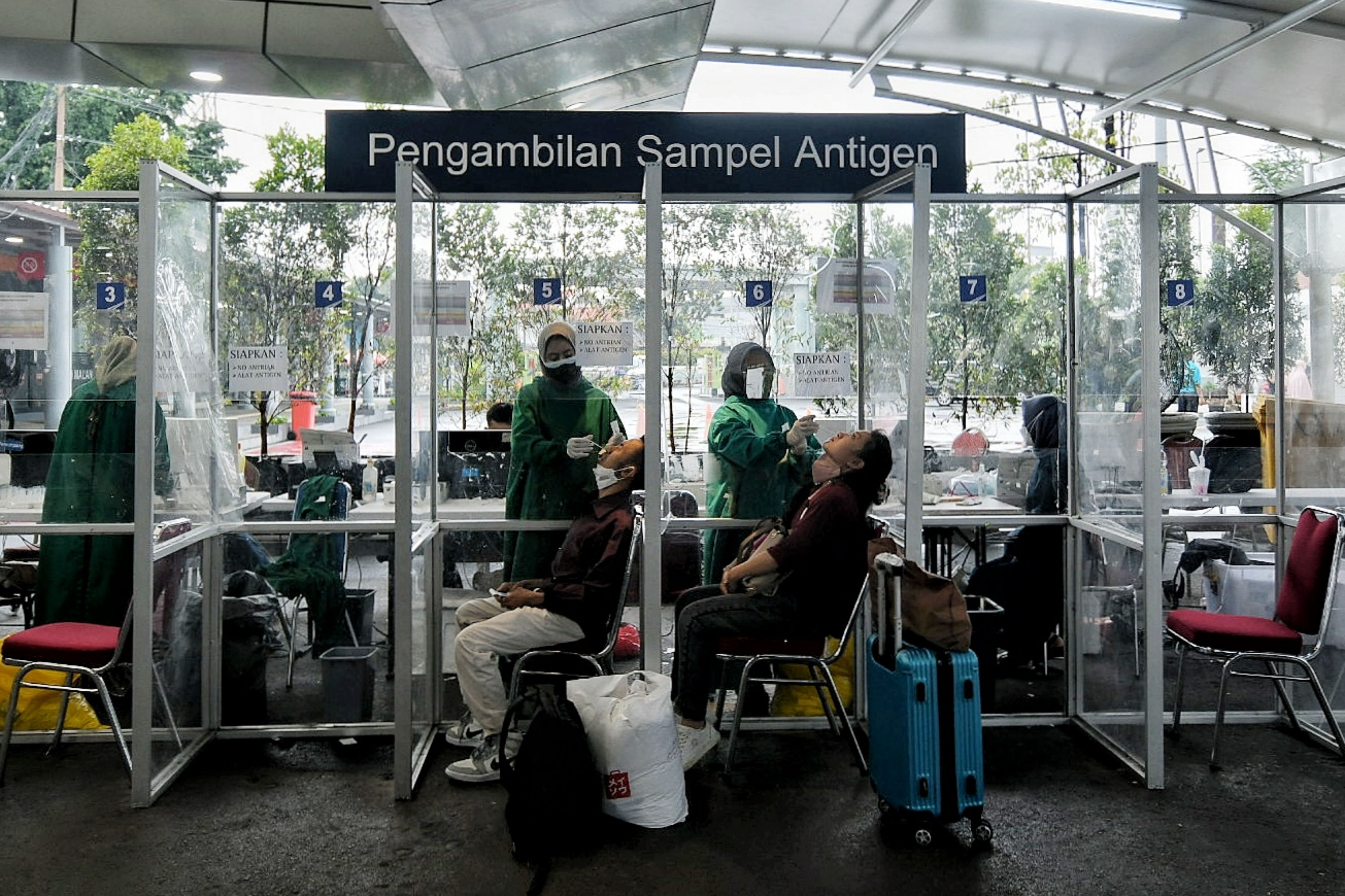 Petugas kesehatan melakukan tes covid-19 kepada calon penumpang kereta jarak jauh.