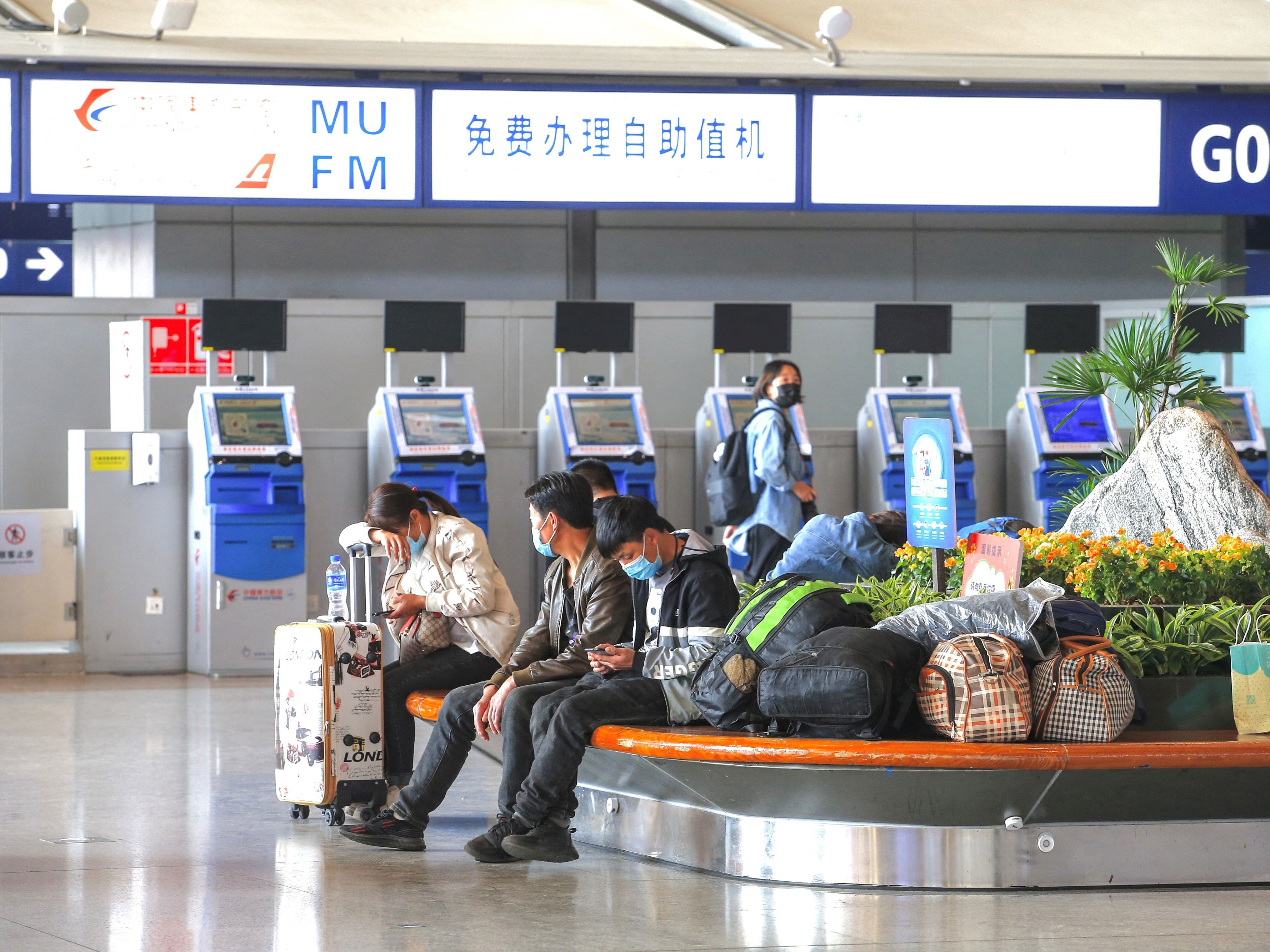 Penumpang duduk di depan mesin swalayan China Eastern Airlines di Bandara Internasional Kunming Changshui di Yunnan, barat daya Tiongkok.