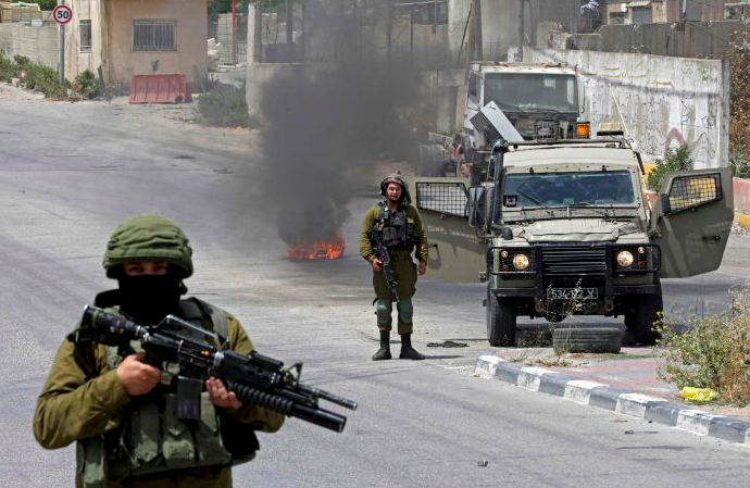 Tentara Israel memegang senjata saat bentrok dengan warga palestina yang merayakan gencatan senjata.