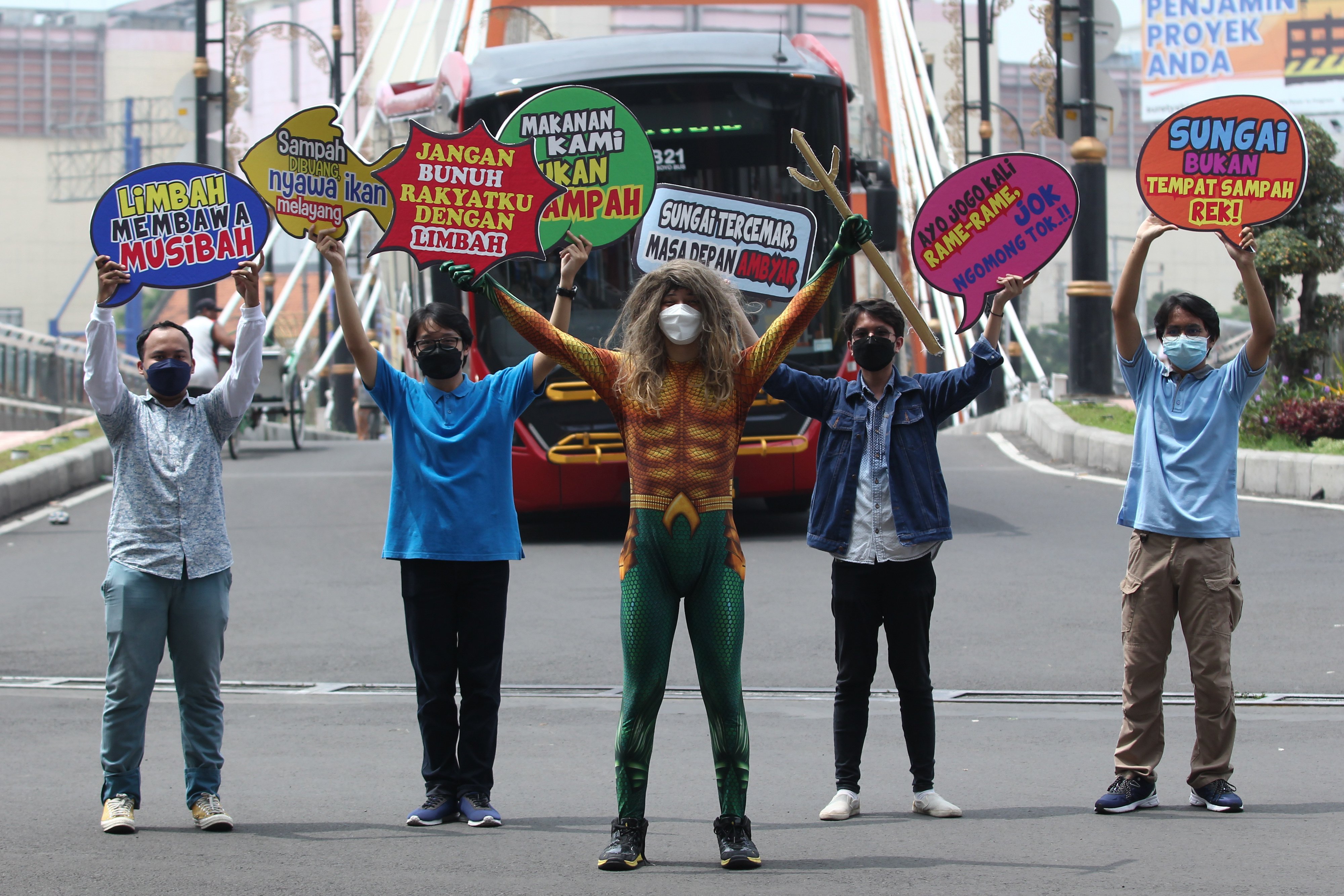 Sejumlah mahasiswa Universitas Surabaya memajang tulisan dalam aksi di sekitar Sungai Surabaya  Jawa Timur, Senin (21/3/2022).