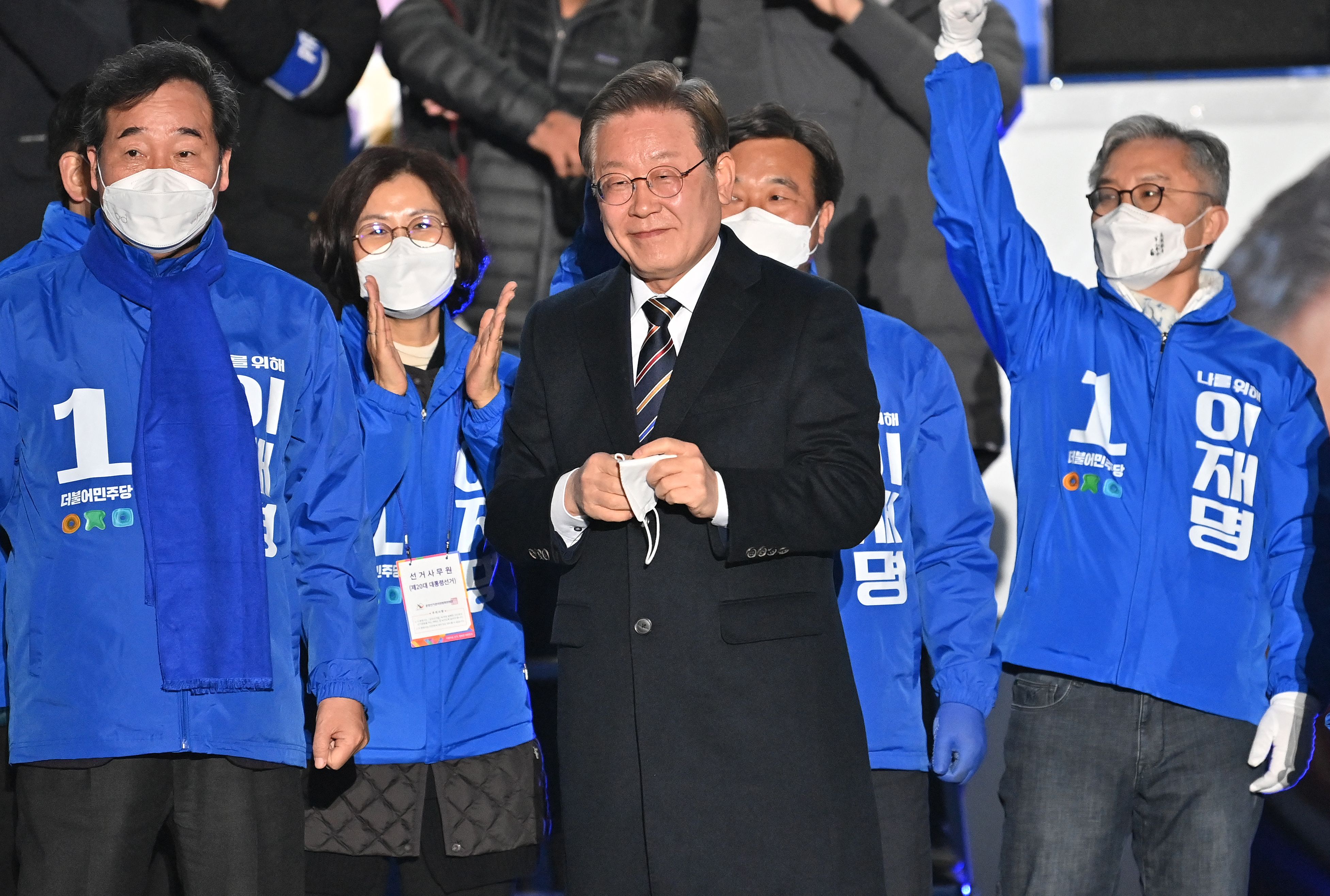 Calon Presiden Lee Jae-myung (tengah) dari Partai Democratik tersenyum saat berkampanye di Kota Seoul, Korea Selatan, Selasa (8/3).