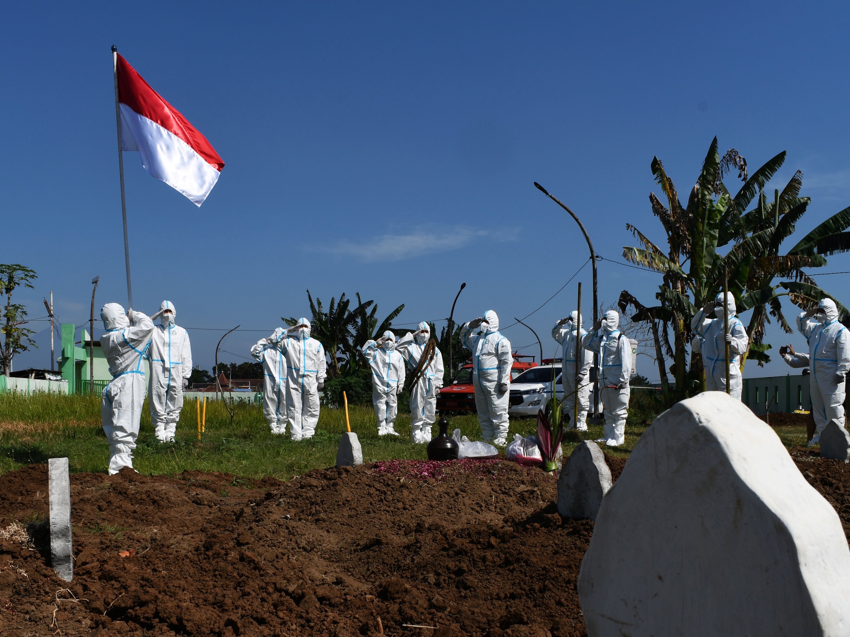 Sejumlah relawan pemakaman jenazah protokol covid-19 dengan mengenakan APD melakukan upacara bendera, Kota Madiun, Jatim, tahun lalu.