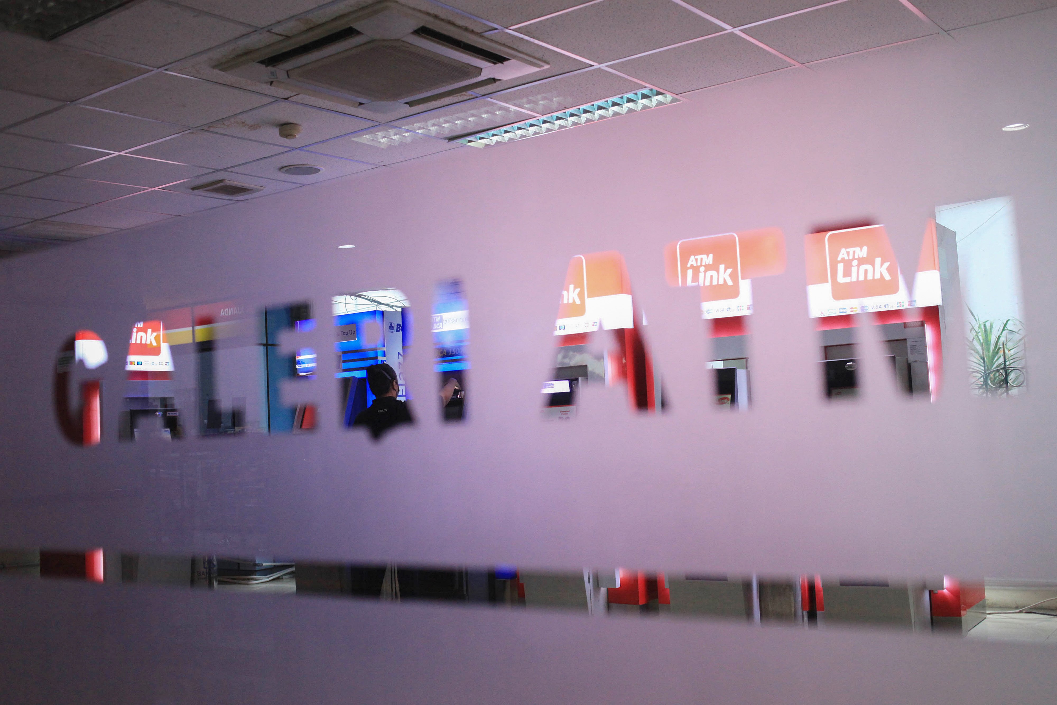 Warga bertansaksi melalui mesin anjungan tunai mandiri (ATM) di Galeri ATM Stasiun KA Juanda, Jakarta