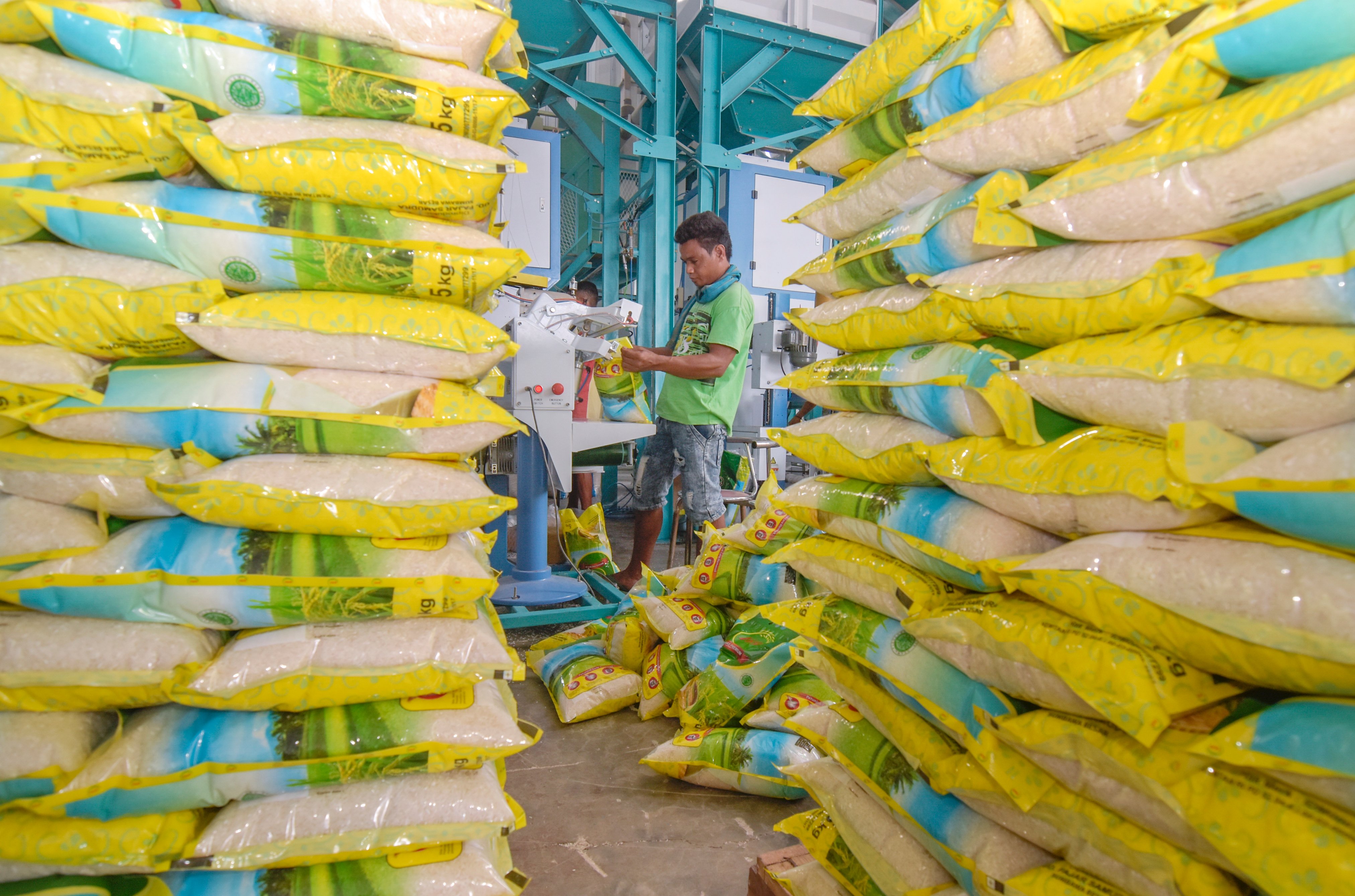 Pekerja mengemas produk beras premium di pabrik penggilingan wilayah Sumbawa Besar, NTB.