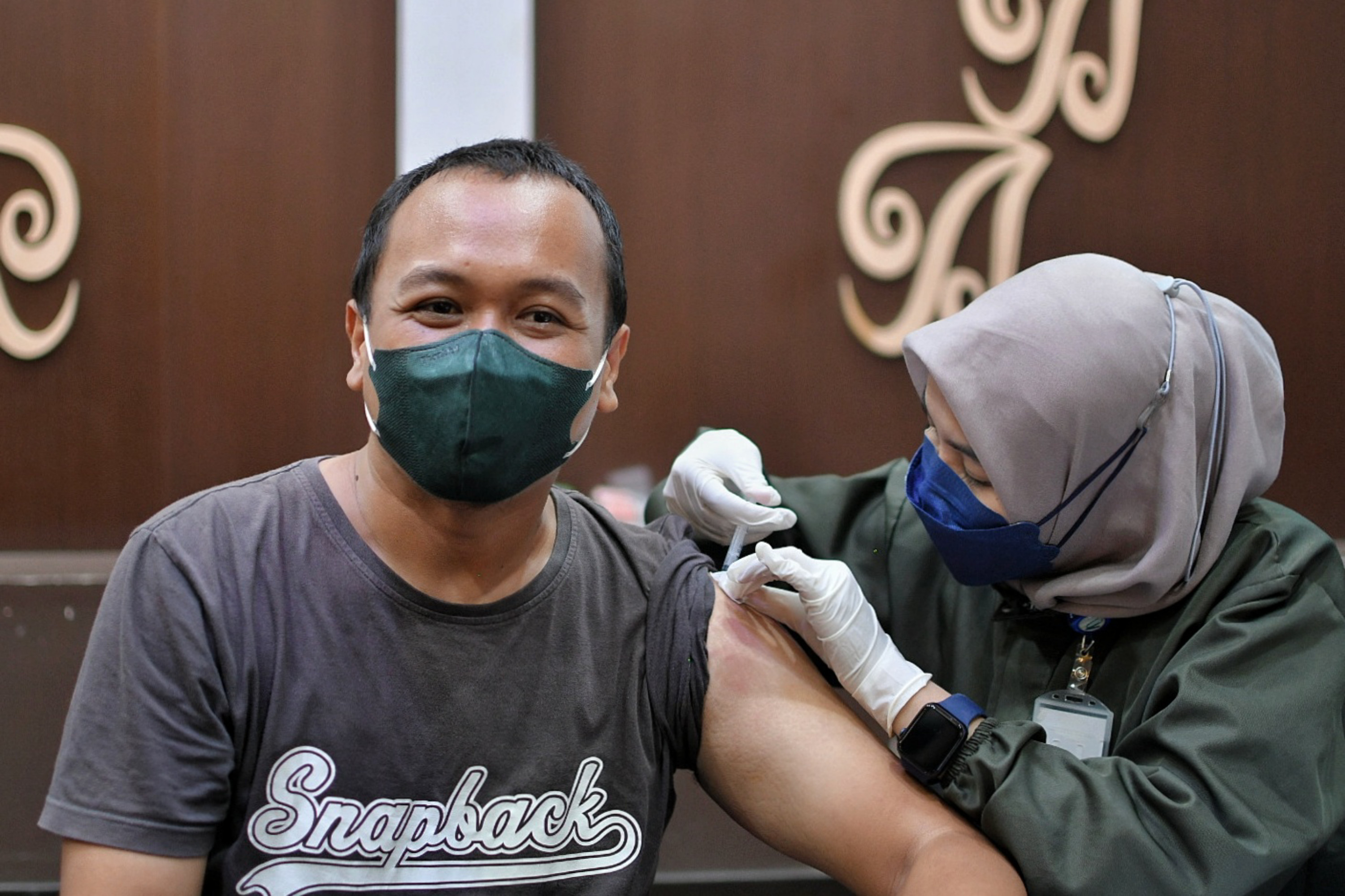  Tenaga kesehatan menyuntikkan vaksin astrazeneca dosis ketiga kepada warga saat vaksinasi booster Covid-19 di Jakarta.