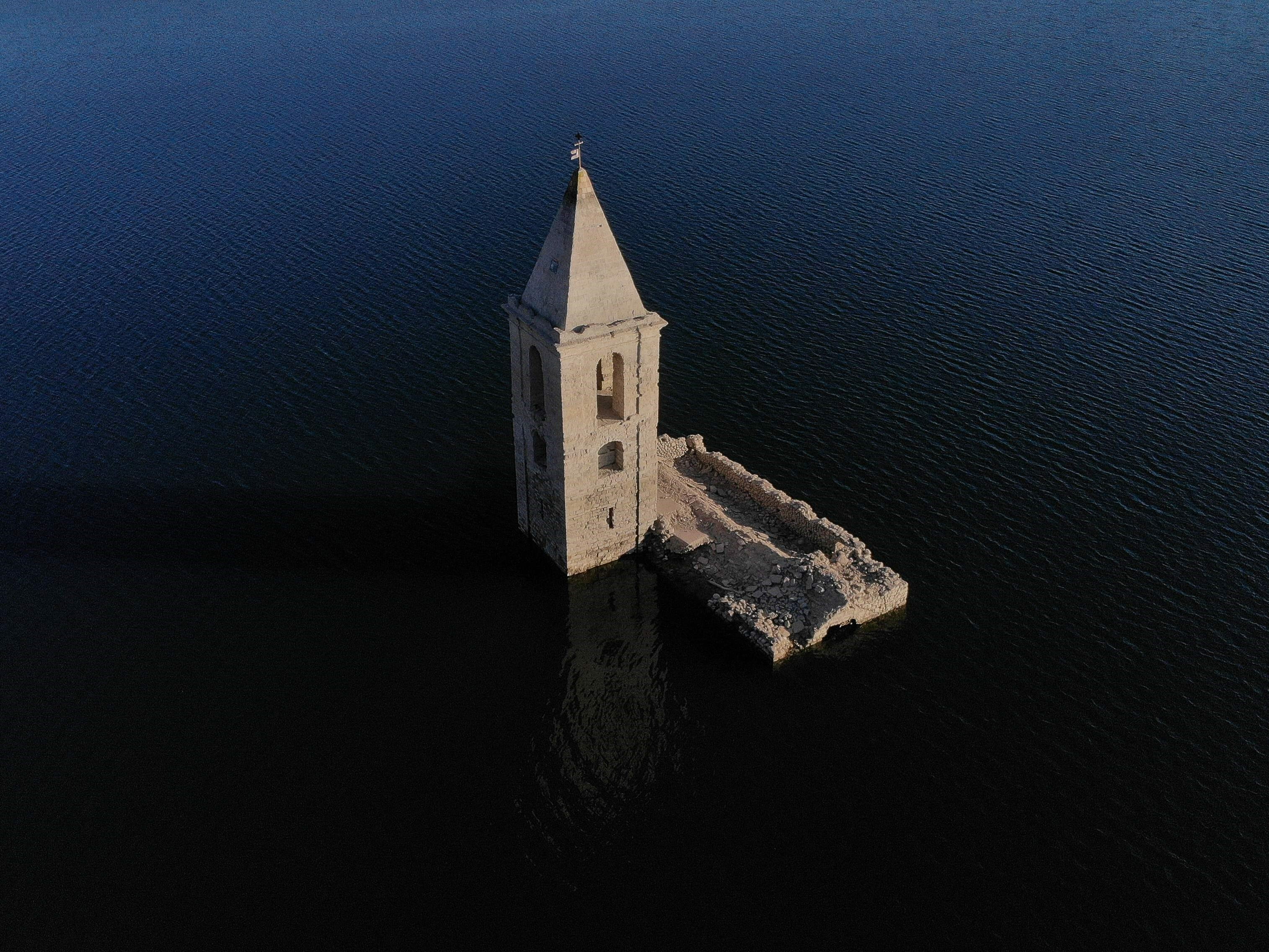 Gereja Sant Roma yang terendam sebagian, terlihat karena rendahnya permukaan air waduk Sau, Vilanova de Sau, Catalonia, Spanyol.