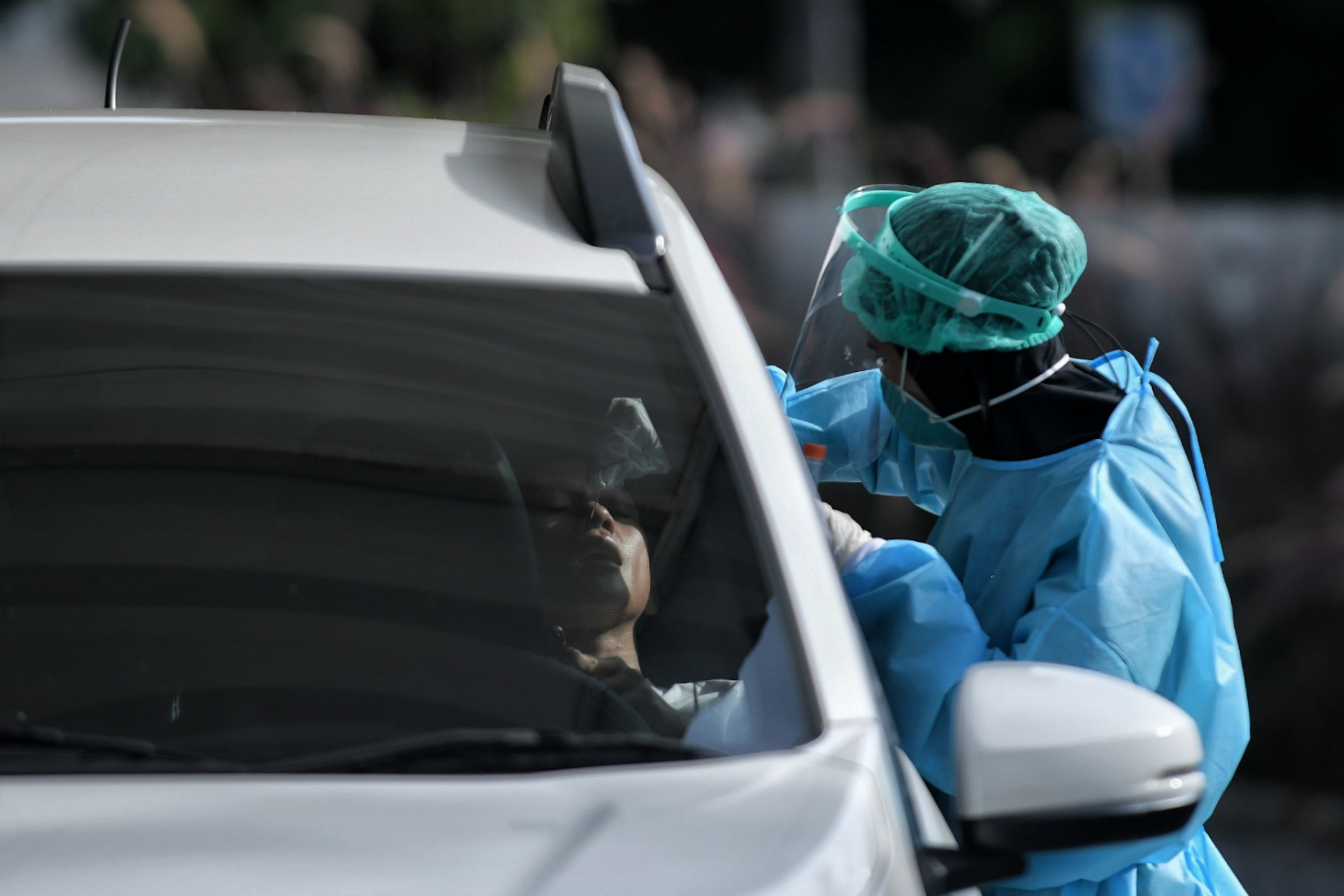 Ilustrasi petugas melakukan tes covid-19 secara drive thru.