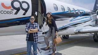 Gilang Widya Pramana dan Shandy Purnamasari berpose di pesawat jet. 
