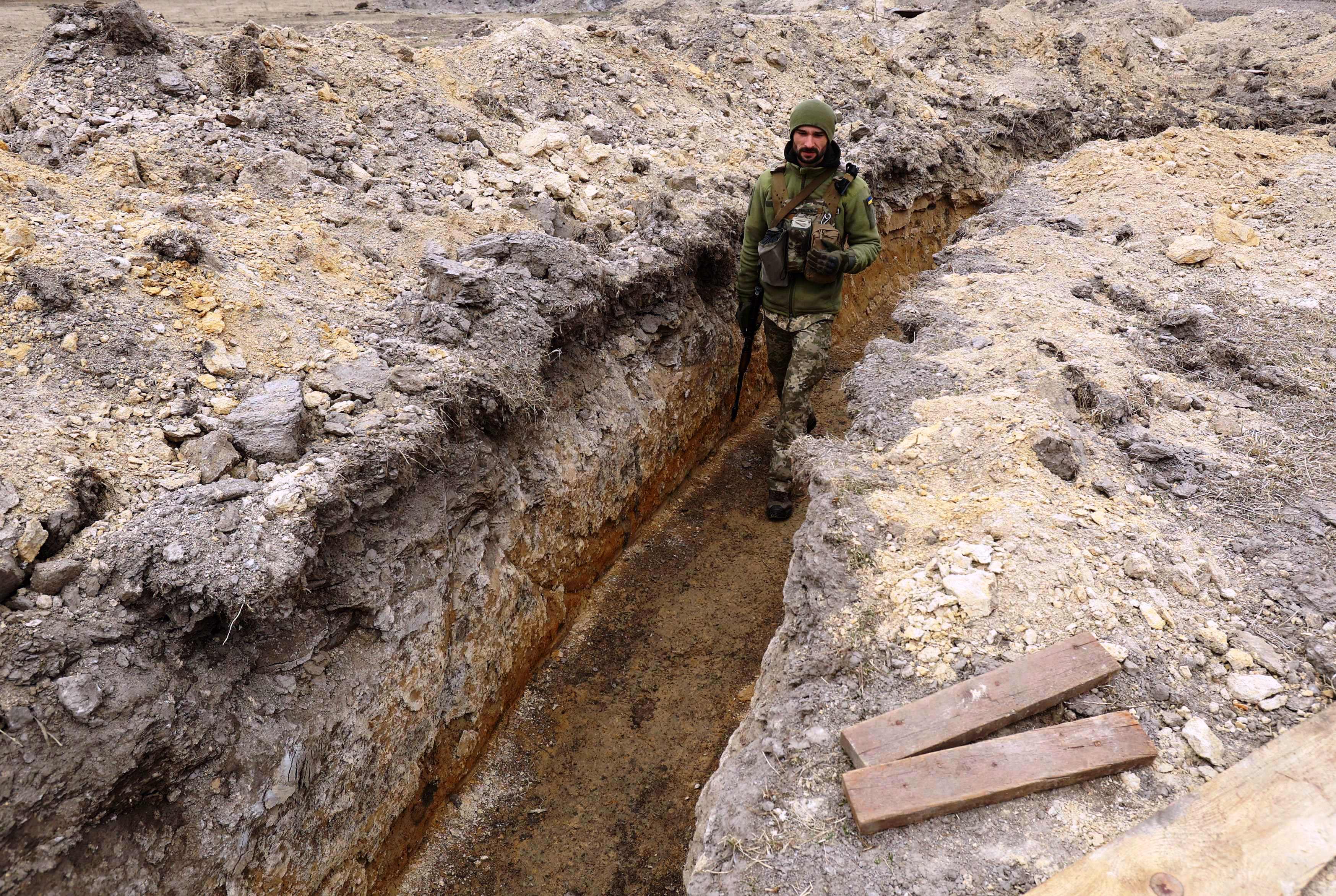 Seorang tentara Ukraina berjalan di parit sebagai pertahanan garis depan wilayah utara Kota Kyiv, Ukraina, pada Senin (28/3).
